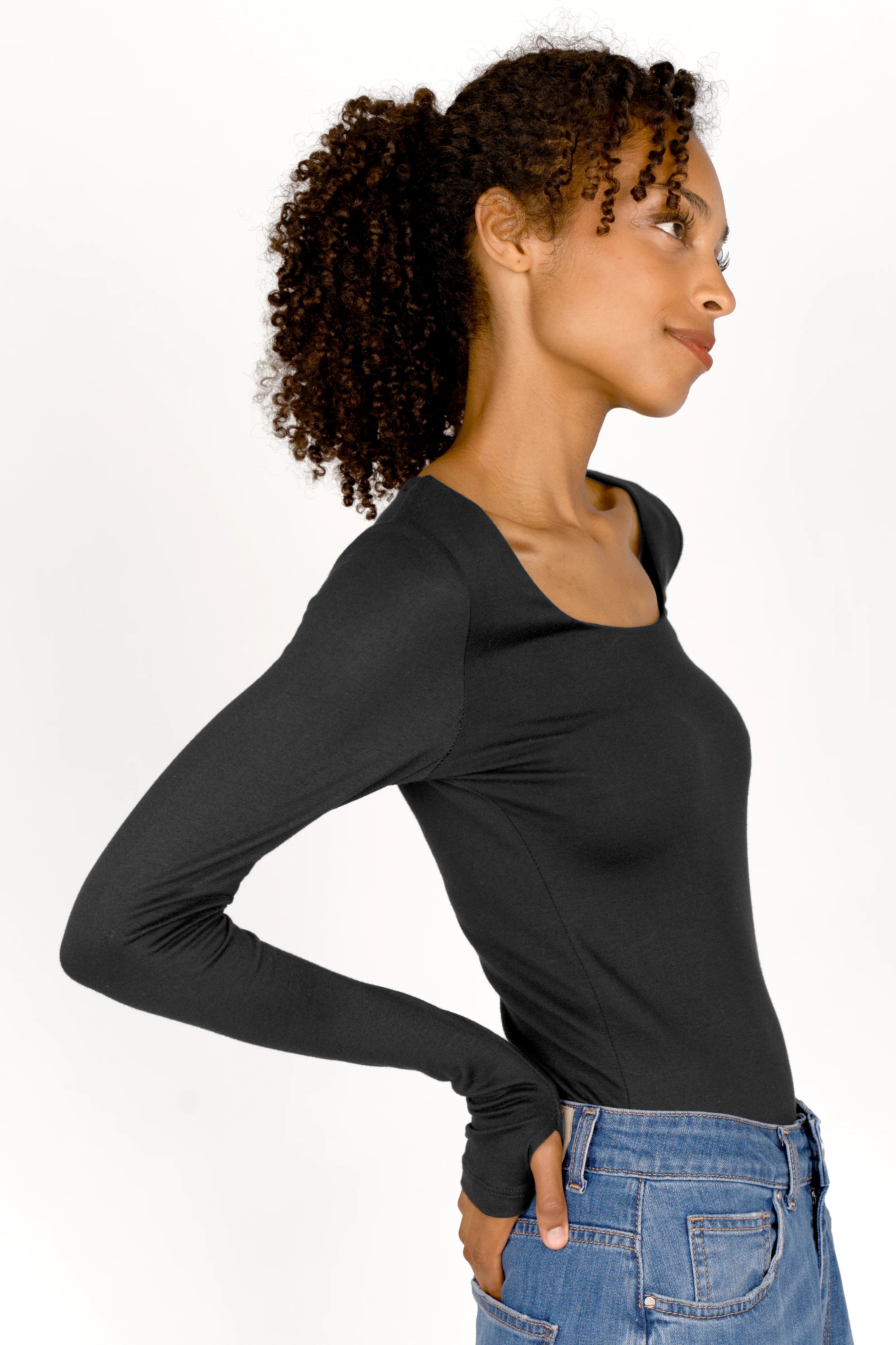 Woman wearing black VALUM Longsleeve with thumbholes and boat neckline in profile