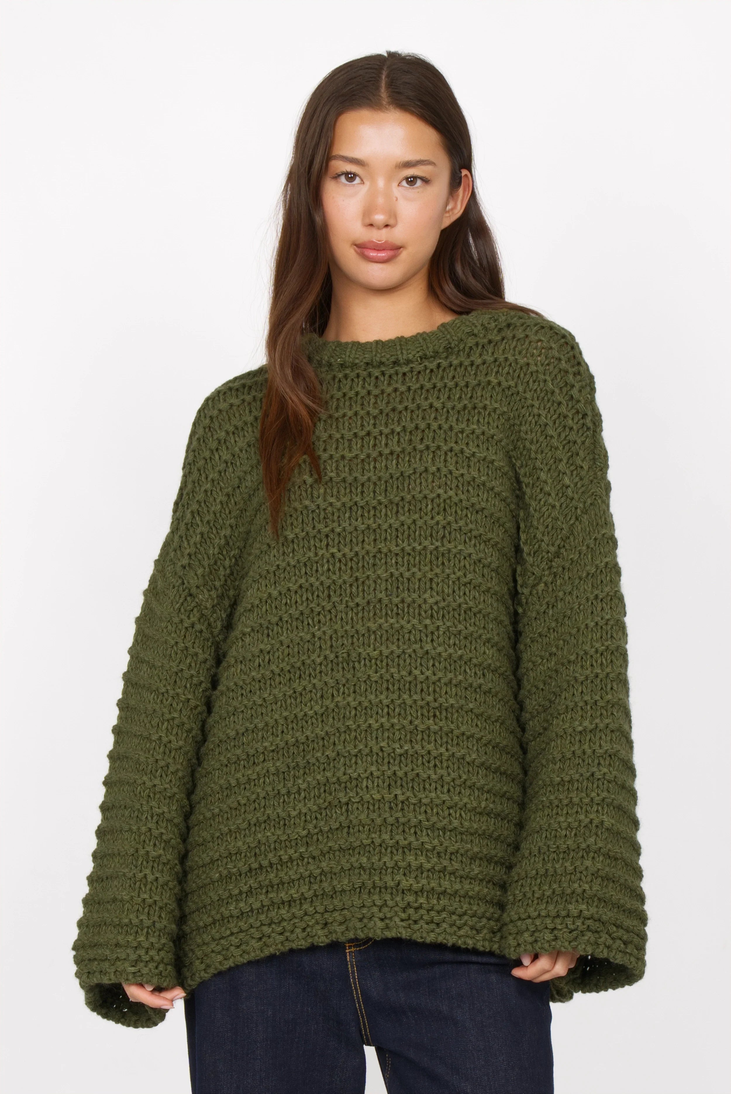 Frau trägt olivgrünen oversized Pullover mit Grobstrick im Chunky-Knit-Look und Rundhalsausschnitt