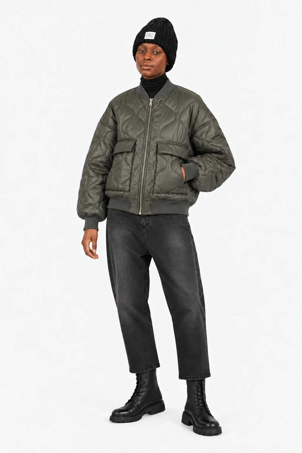 LARNA Padded Winter-Bomberjacke in Green Frost, geschlossene Ganzkörperansicht mit JEANY Baggy Jeans in Faded Black und schwarzen Boots.