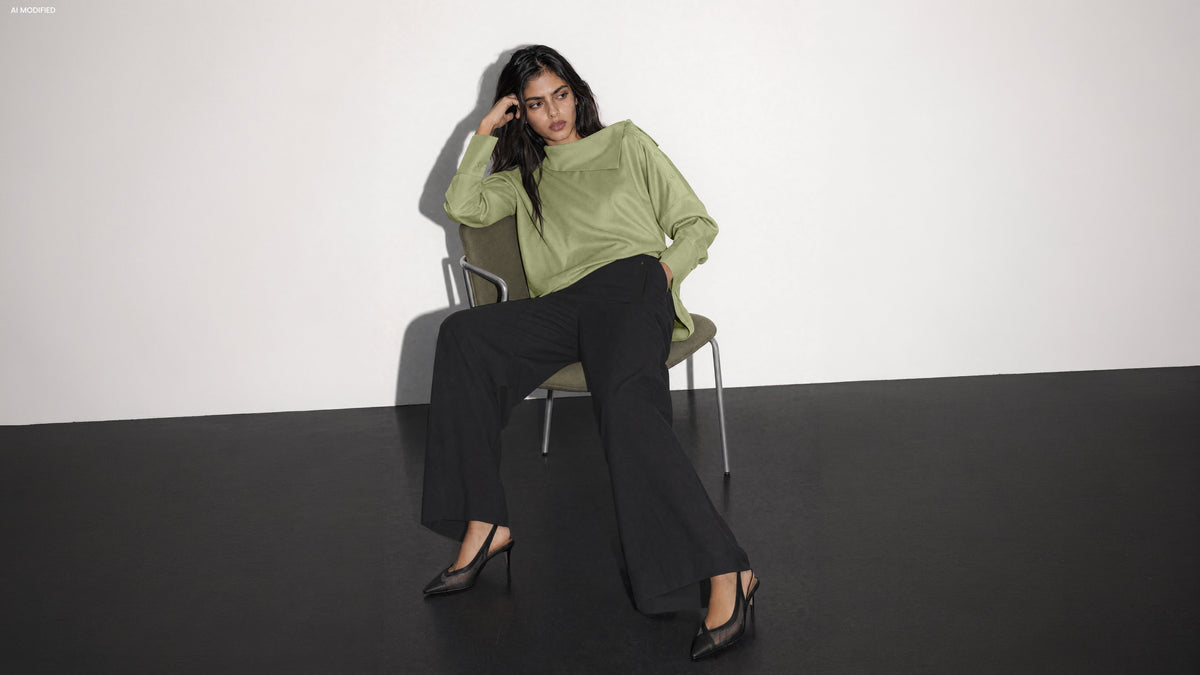 Neuheiten: Model im hellgrauen LOLLYTA Strickcardigan und weiter blauer JOOSY Jeans auf einer Steintreppe vor Säulen – AI modified