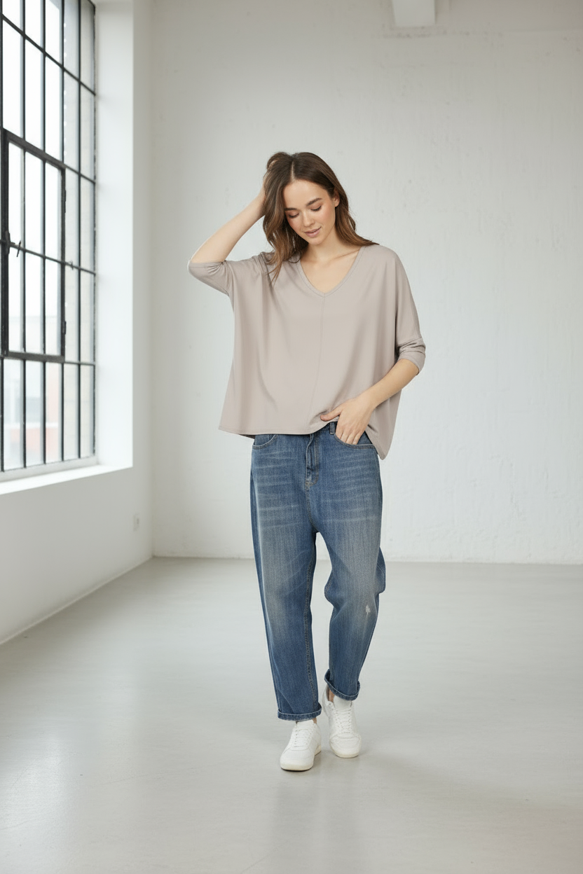 Damen trägt TIDA Blusenshirt mit V-Ausschnitt und lockerem Schnitt in heller Farbe