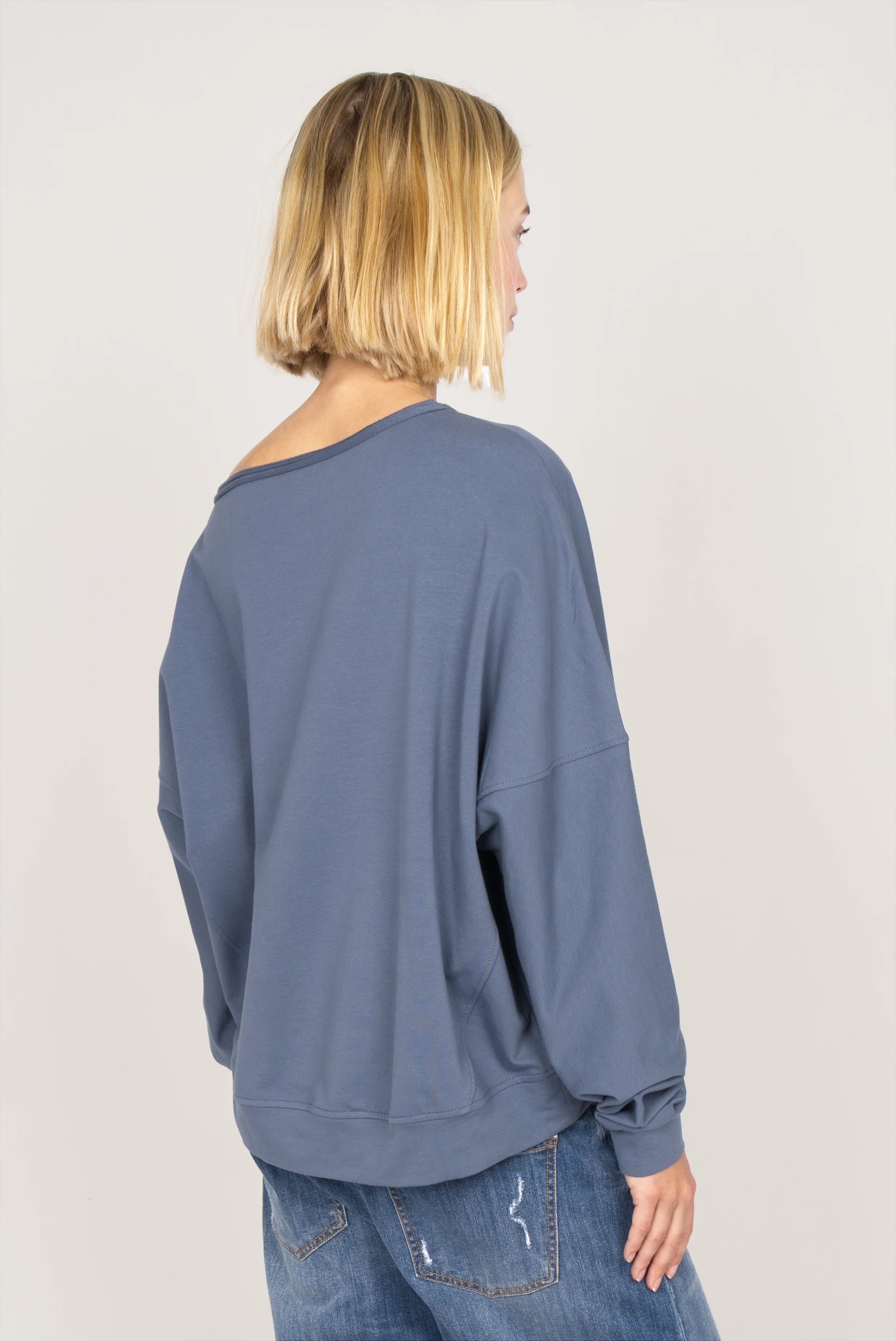 Damen One Shoulder Sweater aus weichem Sweatstoff mit weitem Halsausschnitt und loose Fit, hinten länger geschnitten.
