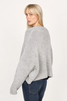Woman wearing grey ALIXA Cropped Strickcardigan with loose fit and ribbed cuffs, back view