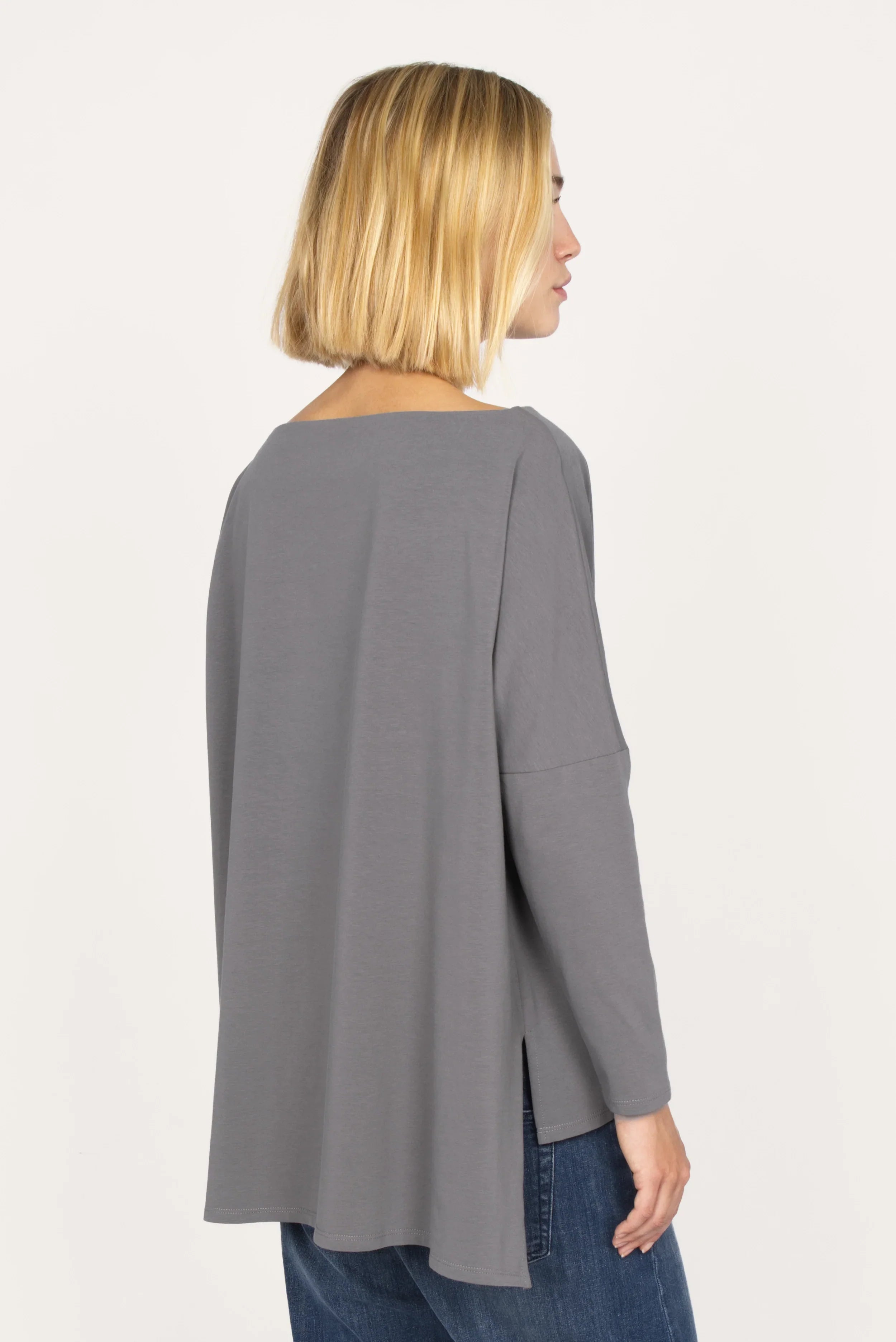 AMALEA Relaxed Fit grey longsleeve with boat neckline, dropped shoulders, side slits, and extended back hem worn by female model