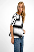 Woman wearing AILIE T-Shirt with black and white stripes, U-boat neckline, and regular fit paired with blue jeans.