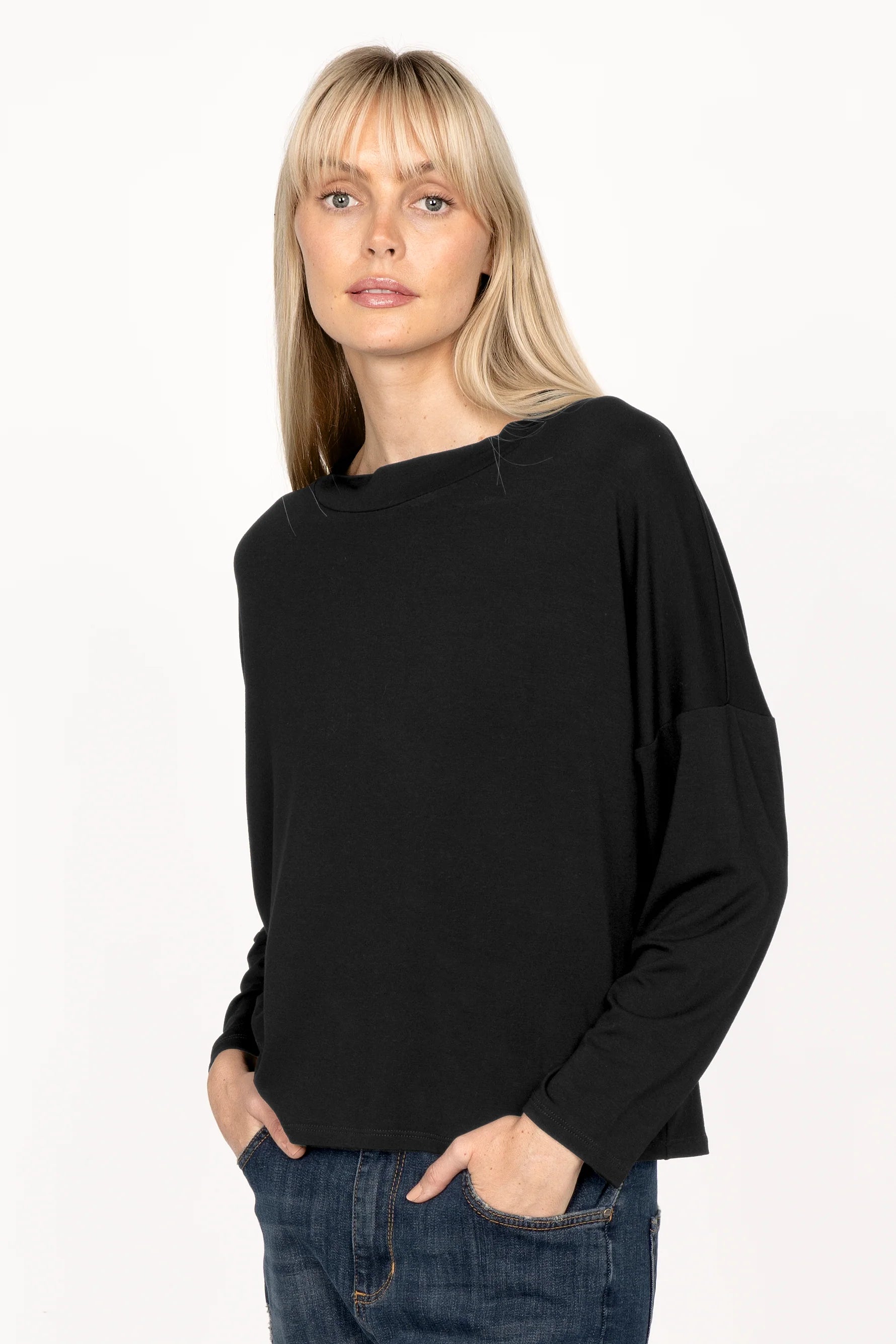 Black longsleeve made of lightweight viscose jersey with relaxed neckline and dropped shoulders worn by woman