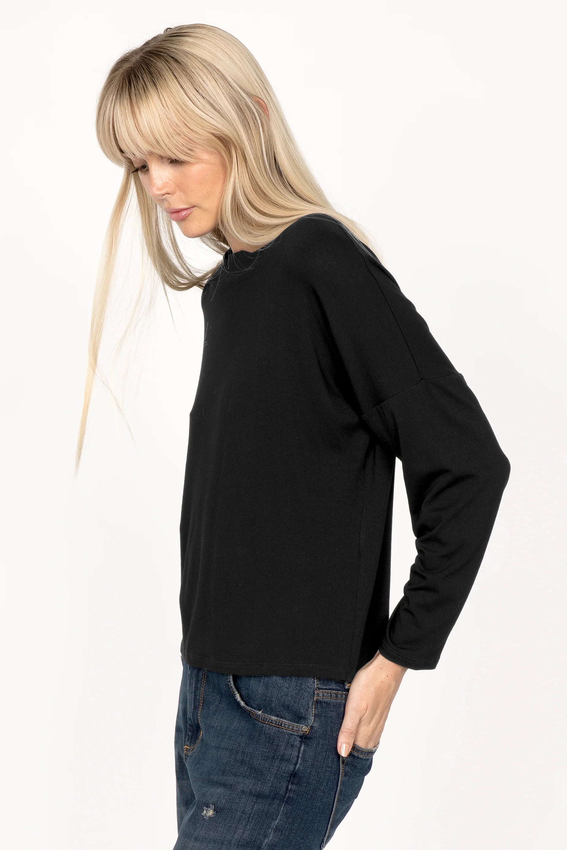 Woman wearing black longsleeve made of lightweight viscose jersey with relaxed neckline and dropped shoulders