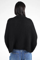 Damen trägt schwarzen ALIXA Cropped Strickcardigan im Oversize-Fit mit Schalkragen und gerippten Abschlüssen, Rückansicht