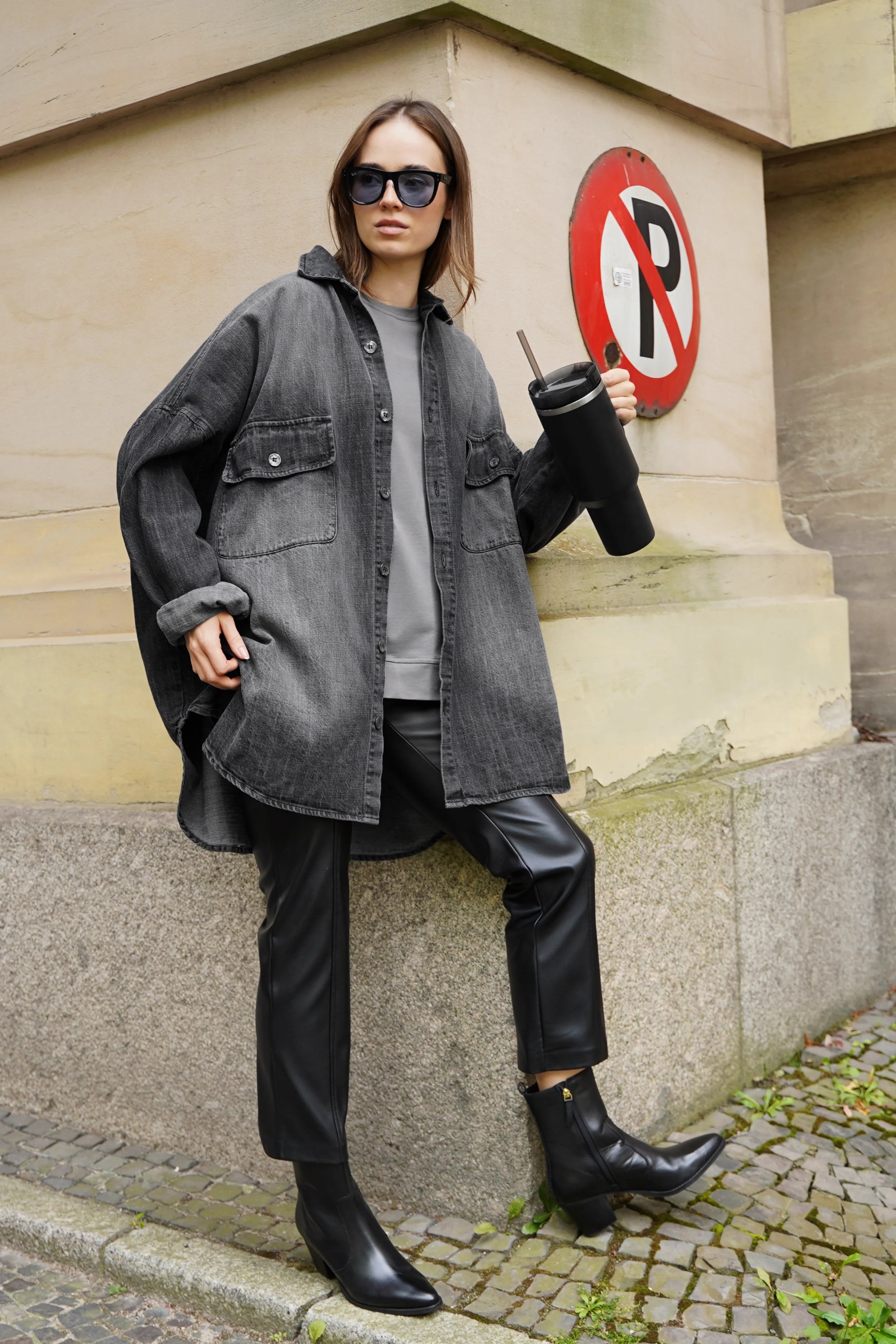 Frau trägt ANEA Oversized Hemdjacke im Denim-Look mit Brusttaschen und abgerundetem Saum.