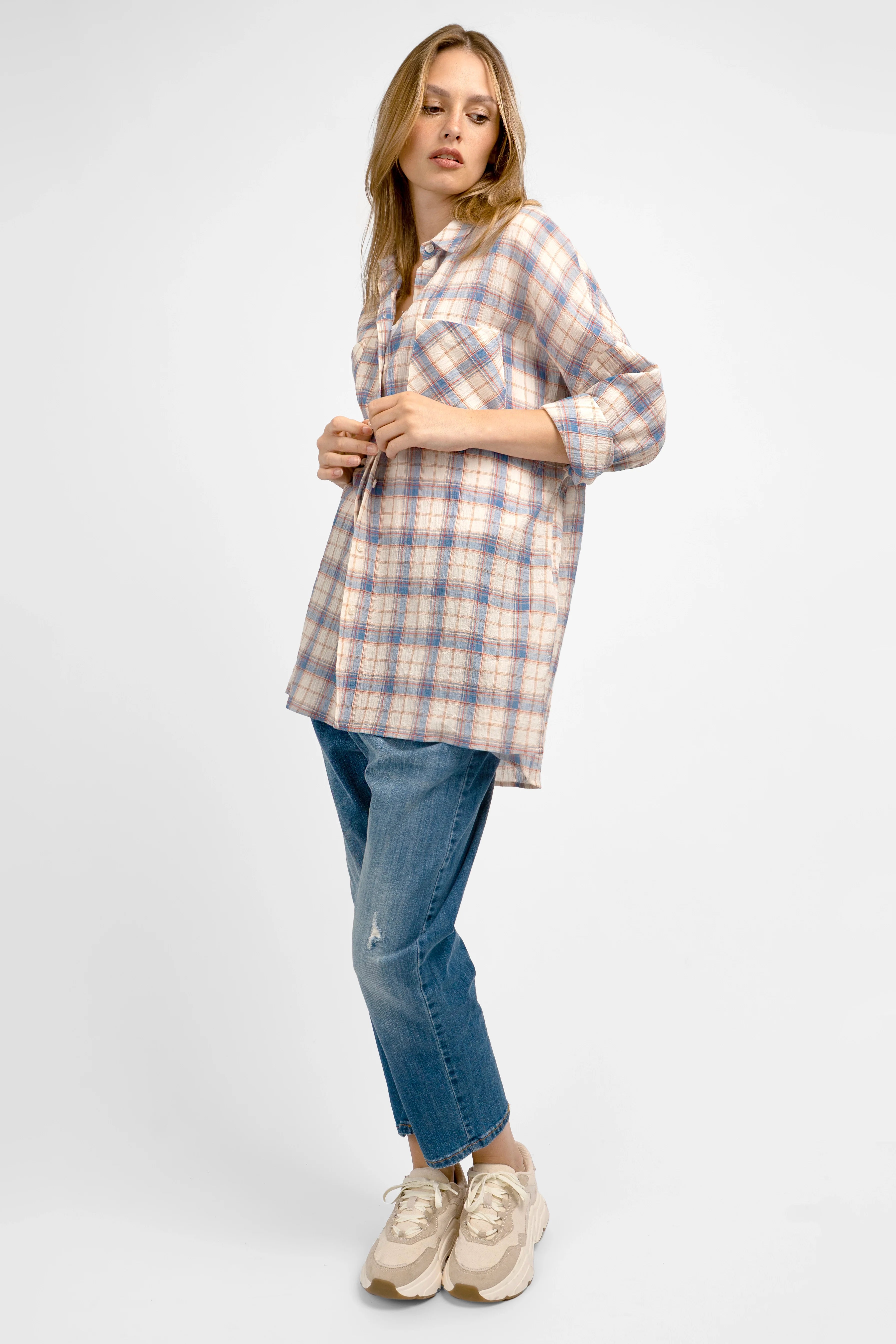 Woman wearing relaxed fit ATLE Hemd with crinkle texture and chest pockets paired with blue jeans and beige sneakers