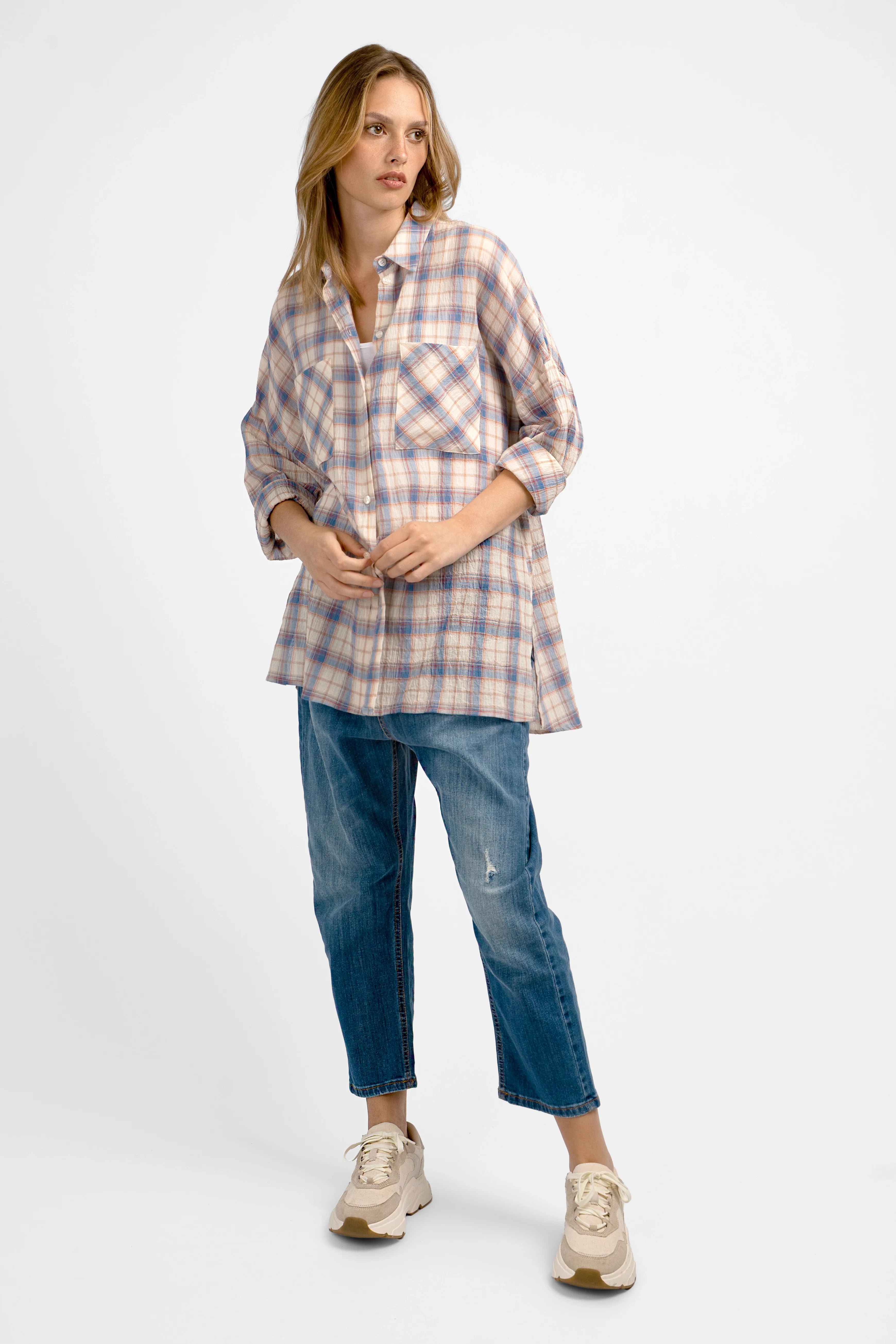 Woman wearing ATLE Hemd relaxed fit crinkle texture plaid shirt with chest pockets and rolled-up sleeves paired with blue jeans and sneakers