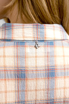 Close-up of the back collar of an ATLE Hemd shirt with a light crinkle texture and blue and orange plaid pattern