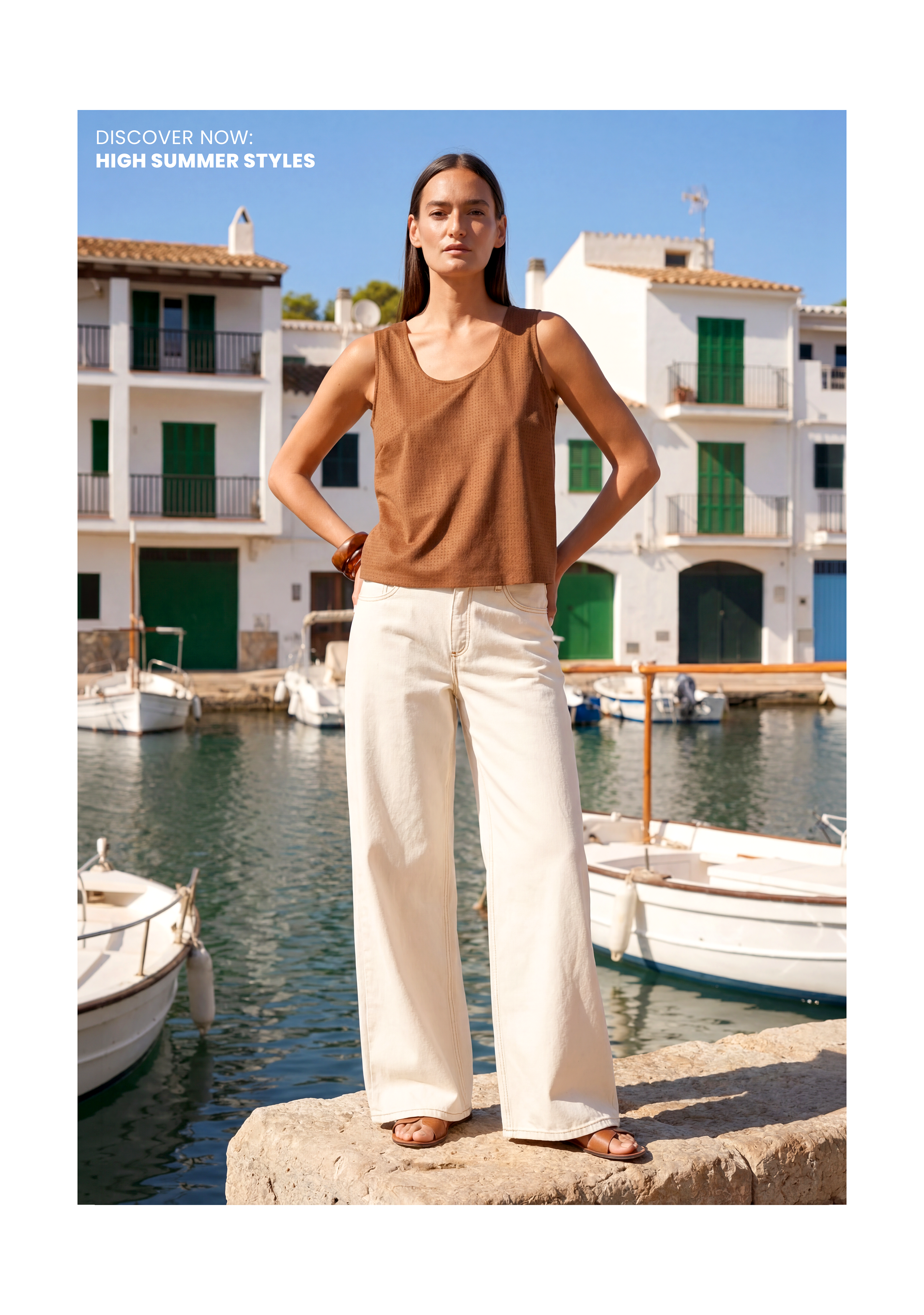 Model im braunen Top und weiter heller Hose am mediterranen Hafen – High Summer Styles Look.