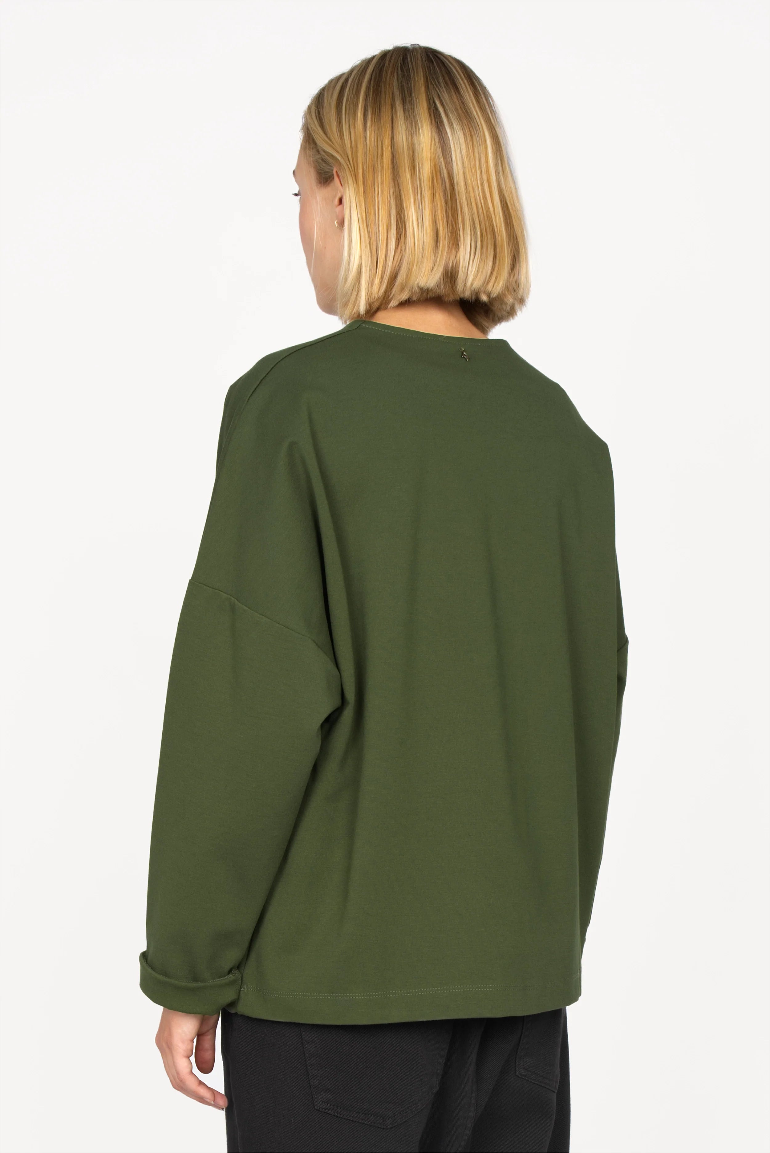 Back view of a person wearing a green BERLEY Relaxed V-Neck Bluse with relaxed fit, dropped shoulders, and long straight sleeves.