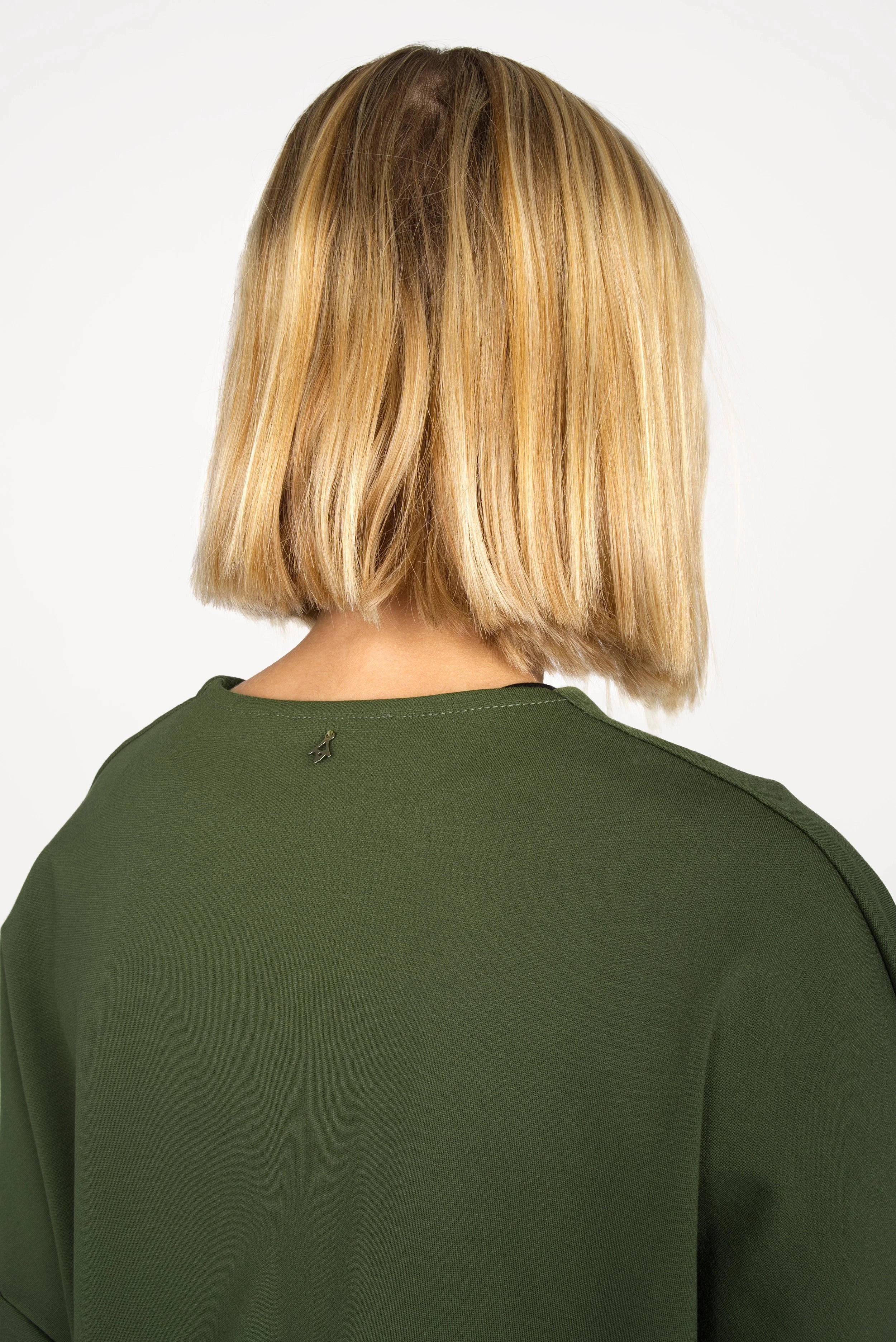 Rückansicht der grünen BERLEY Relaxed V-Neck Bluse aus weichem, formstabilem Jersey mit überschnittenen Schultern und verlängerter Rückenpartie