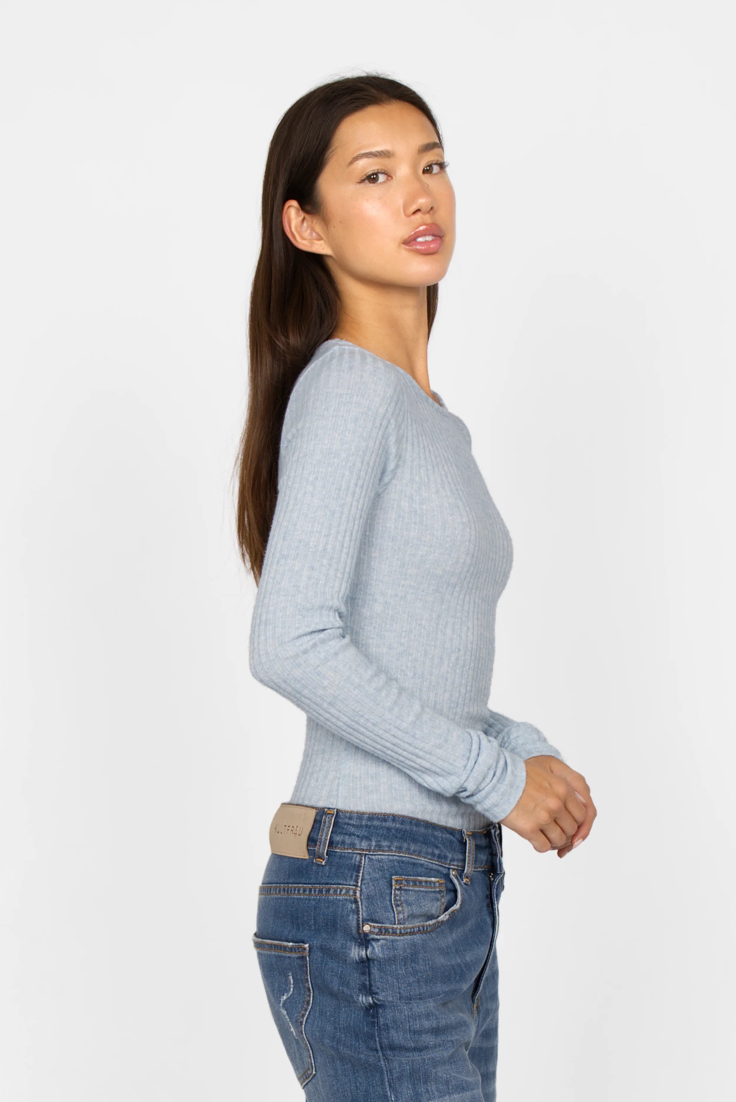 Slim fit BETTIE Longsleeve in light blue with ribbed fine knit, extra long sleeves, and round neckline worn by woman.