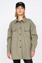 Frau trägt BJORA Overshirt aus festem Wollmix mit aufgesetzten Brusttaschen und oversized Fit in Olivgrün