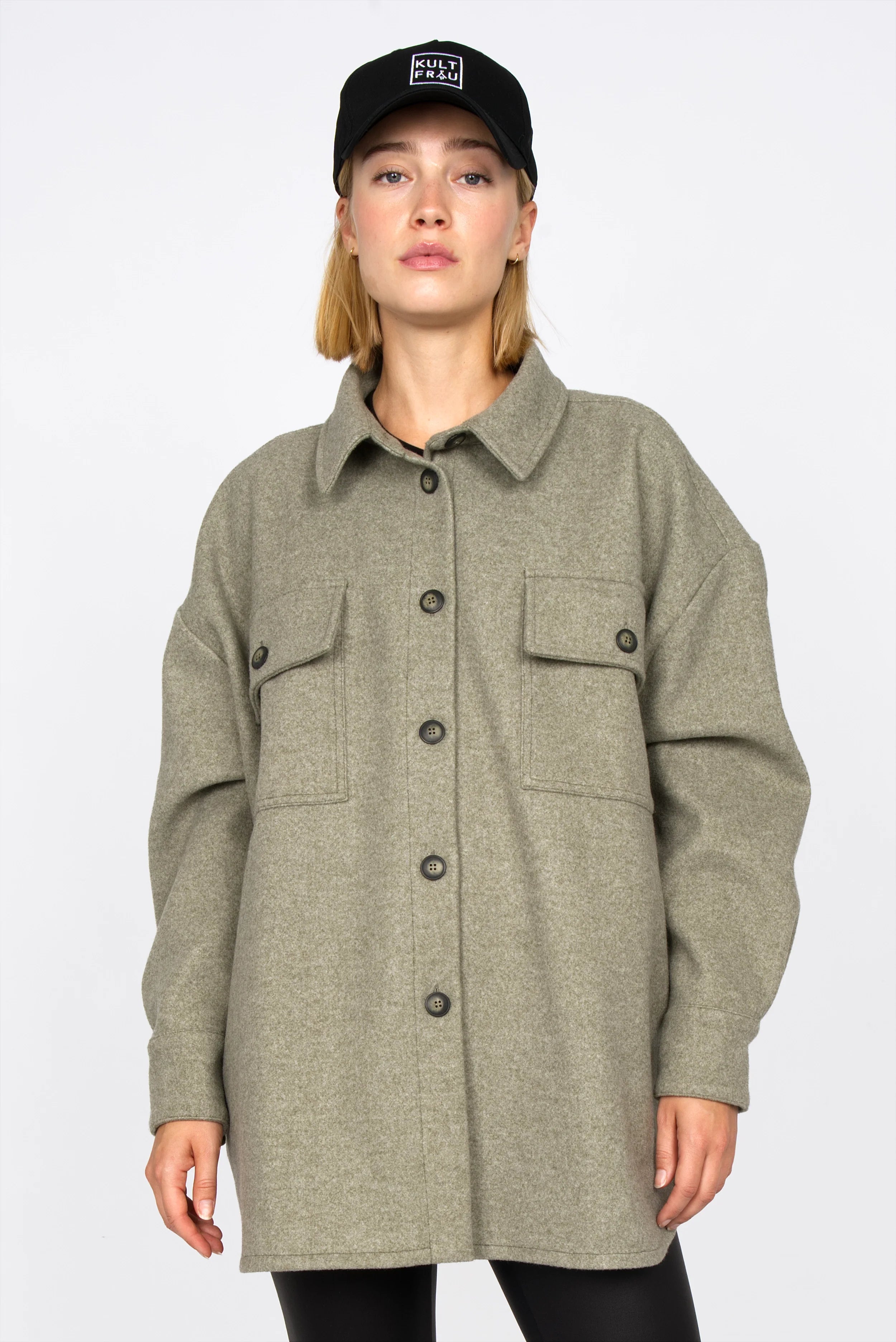 Frau trägt BJORA Overshirt aus festem Wollmix mit aufgesetzten Brusttaschen und oversized Fit in Olivgrün