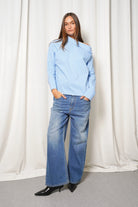 Damen trägt Boni asymmetrische Bluse mit One-Shoulder-Design und verlängerter Rückenpartie