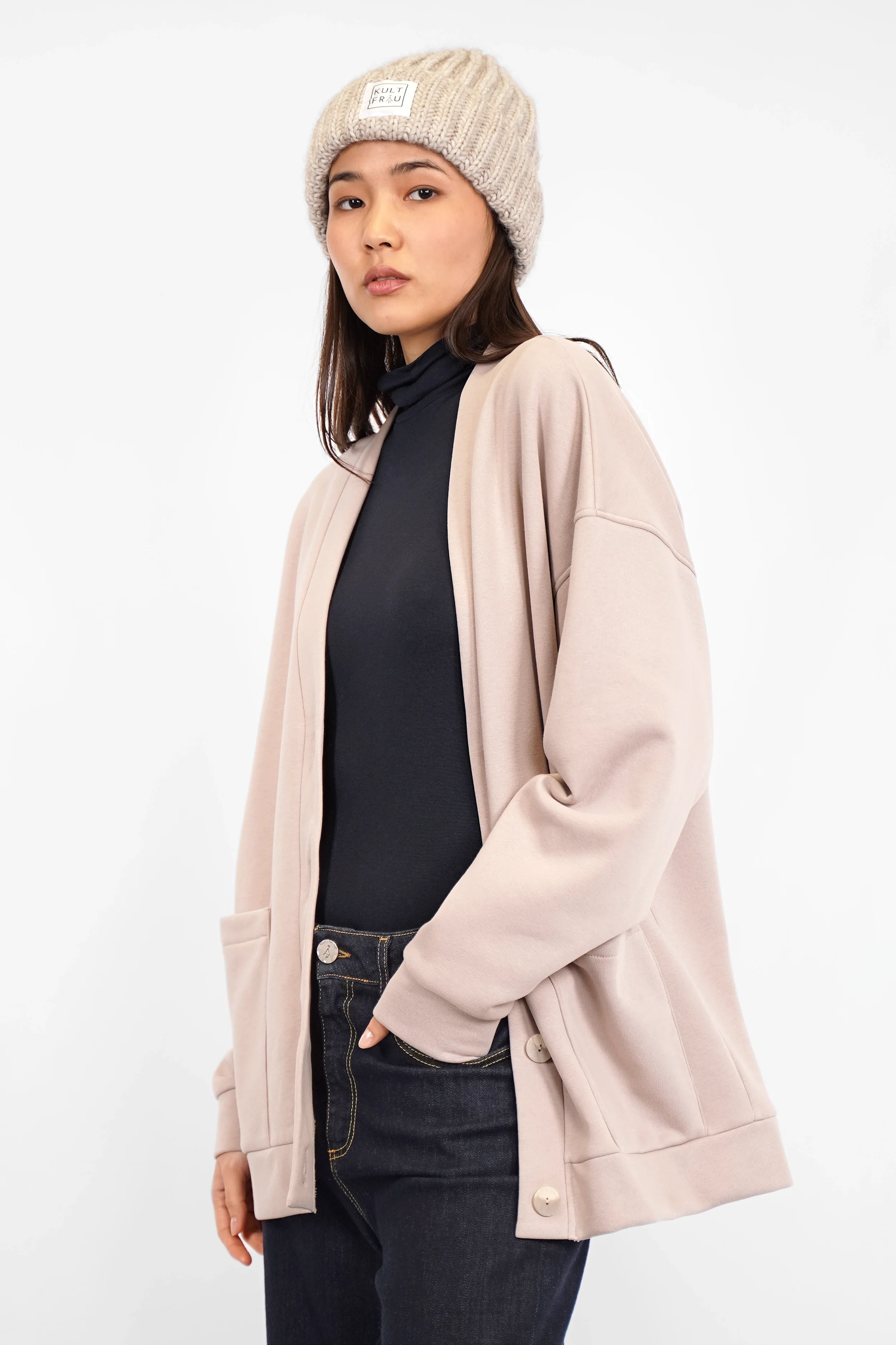 Frau trägt HATY Strickmütze aus grobem Rippstrick mit breitem Umschlag und Kultfrau-Logo