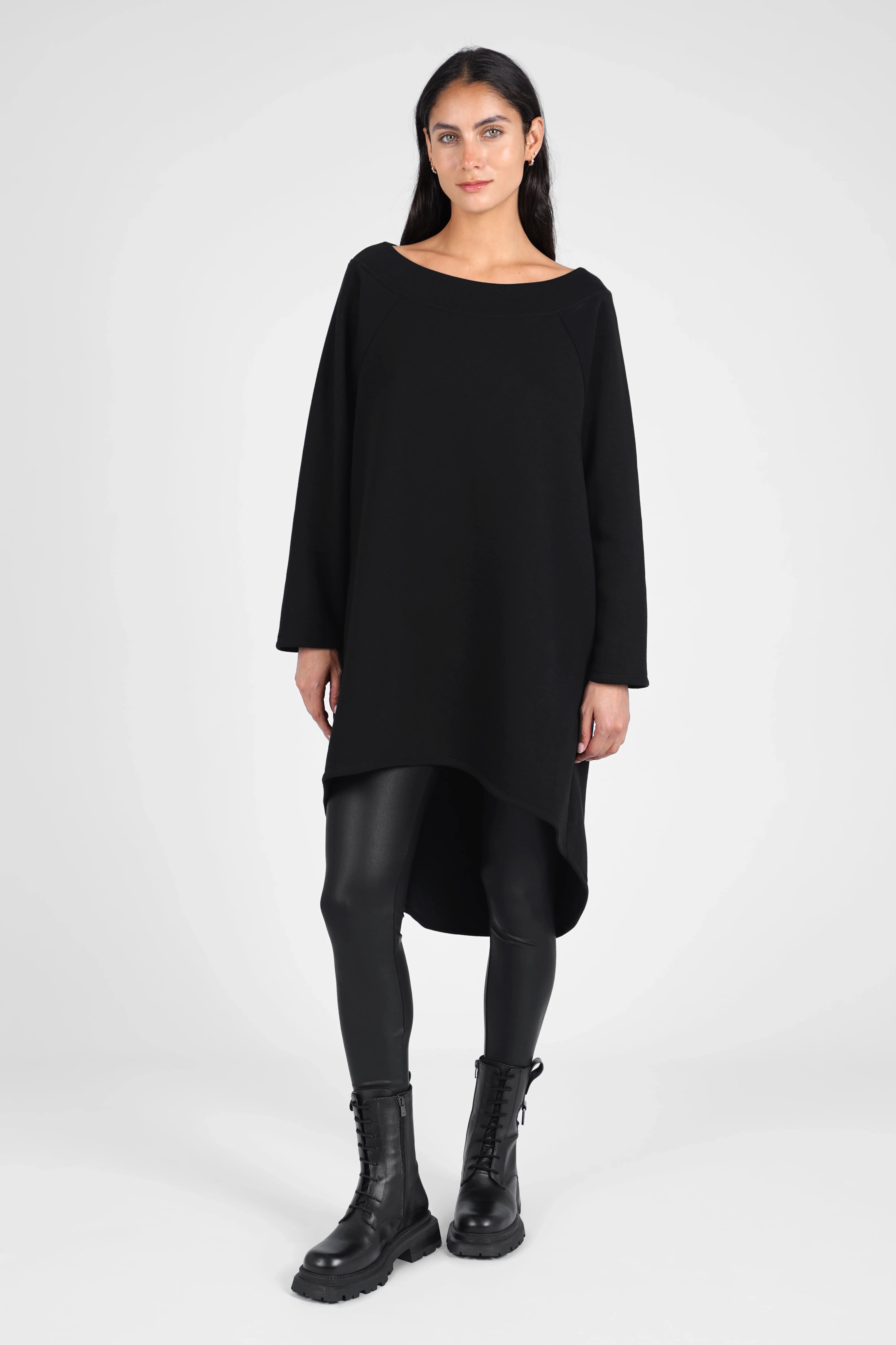 Woman wearing black CHERIN Super-Longsweater with wide boat neckline and relaxed fit styled as dress with leggings and boots