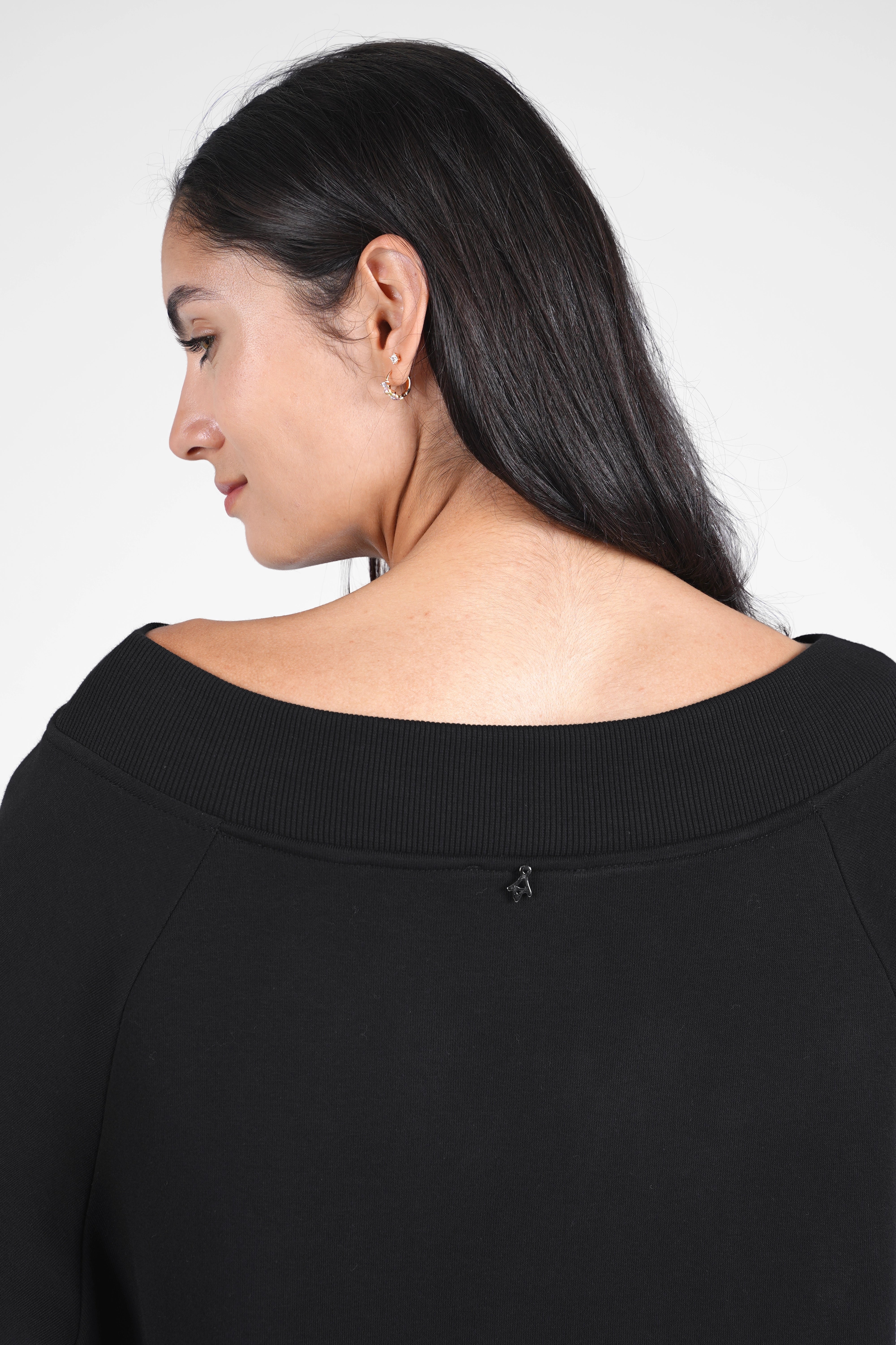 Woman wearing black CHERIN Super-Longsweater with wide boat neckline and relaxed fit shown from back