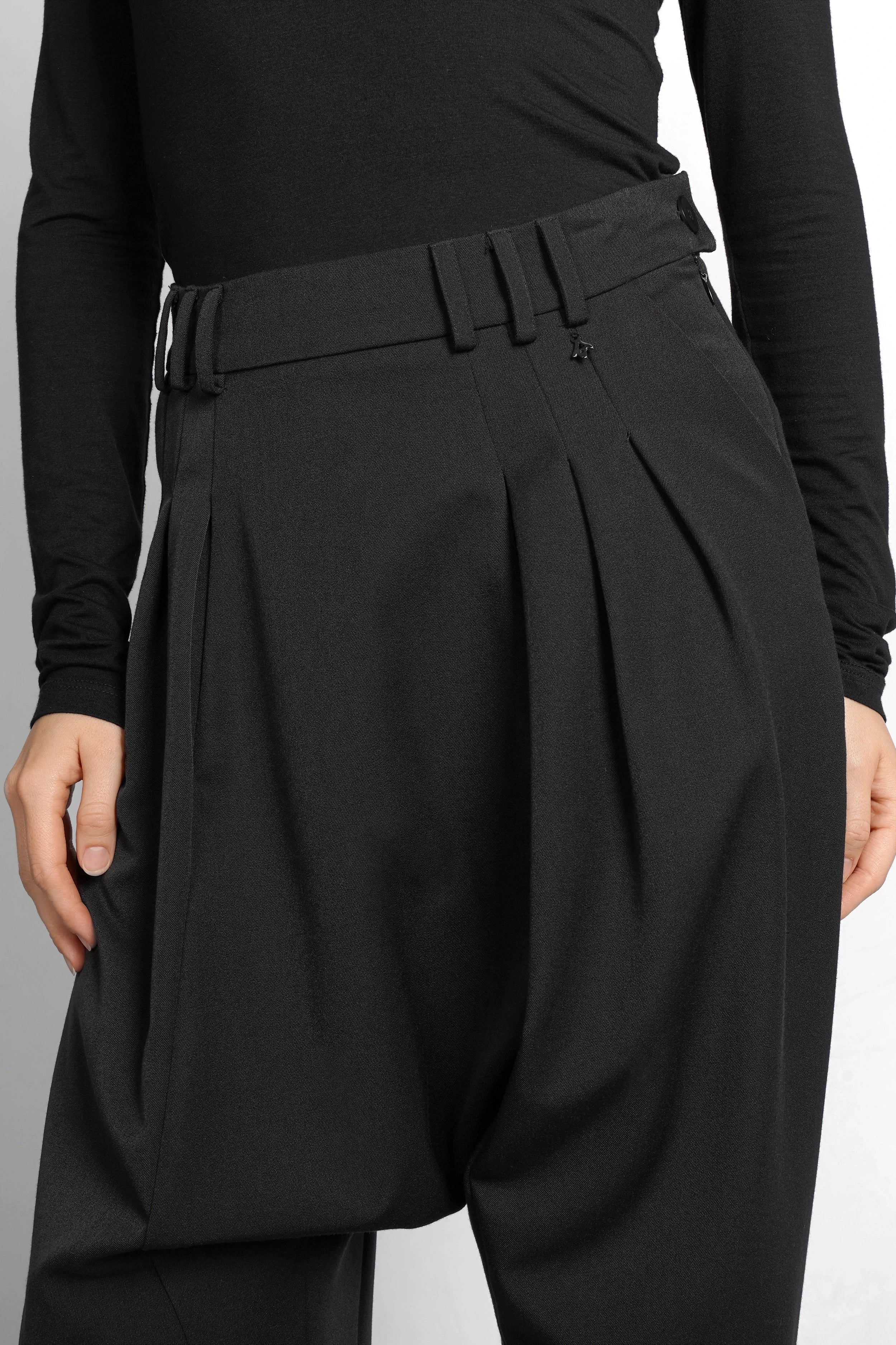 Schwarze DEEP Avantgarde-Hose mit tiefem Schritt, Bundfalten und seitlichem Knopfverschluss für lässigen, modernen Look