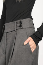 Close-up of RYONI Marlene-Hose in textured grey herringbone fabric with high waist, asymmetrical double button waistband, pleats, and side pocket detail.