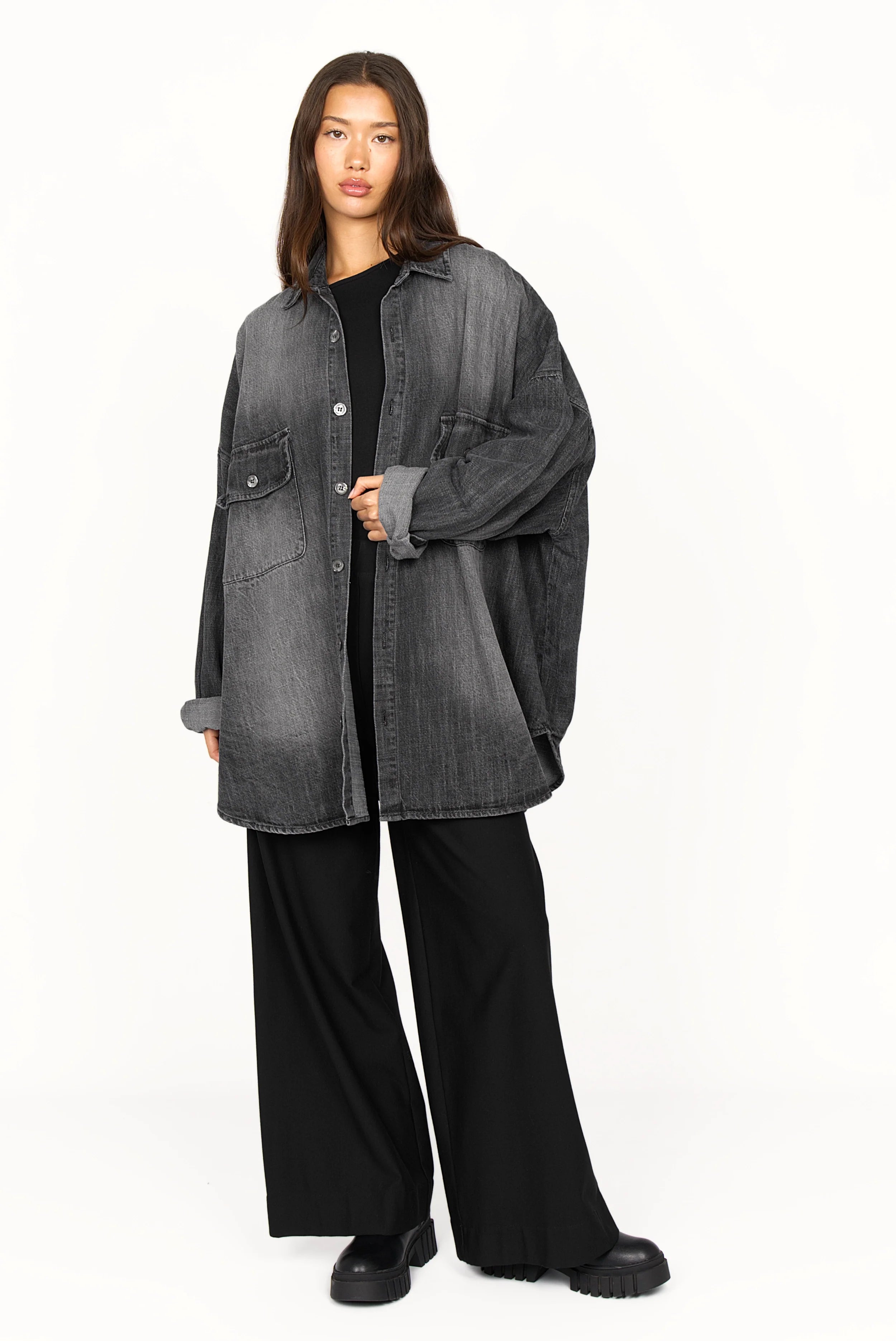 Damen trägt ANEA Oversized Hemdjacke im Denim-Look mit Gradient-Waschung und aufgesetzten Brusttaschen