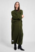 Frau trägt grünen oversized LOLA Strickcardigan mit Taschen und lockerem Schnitt