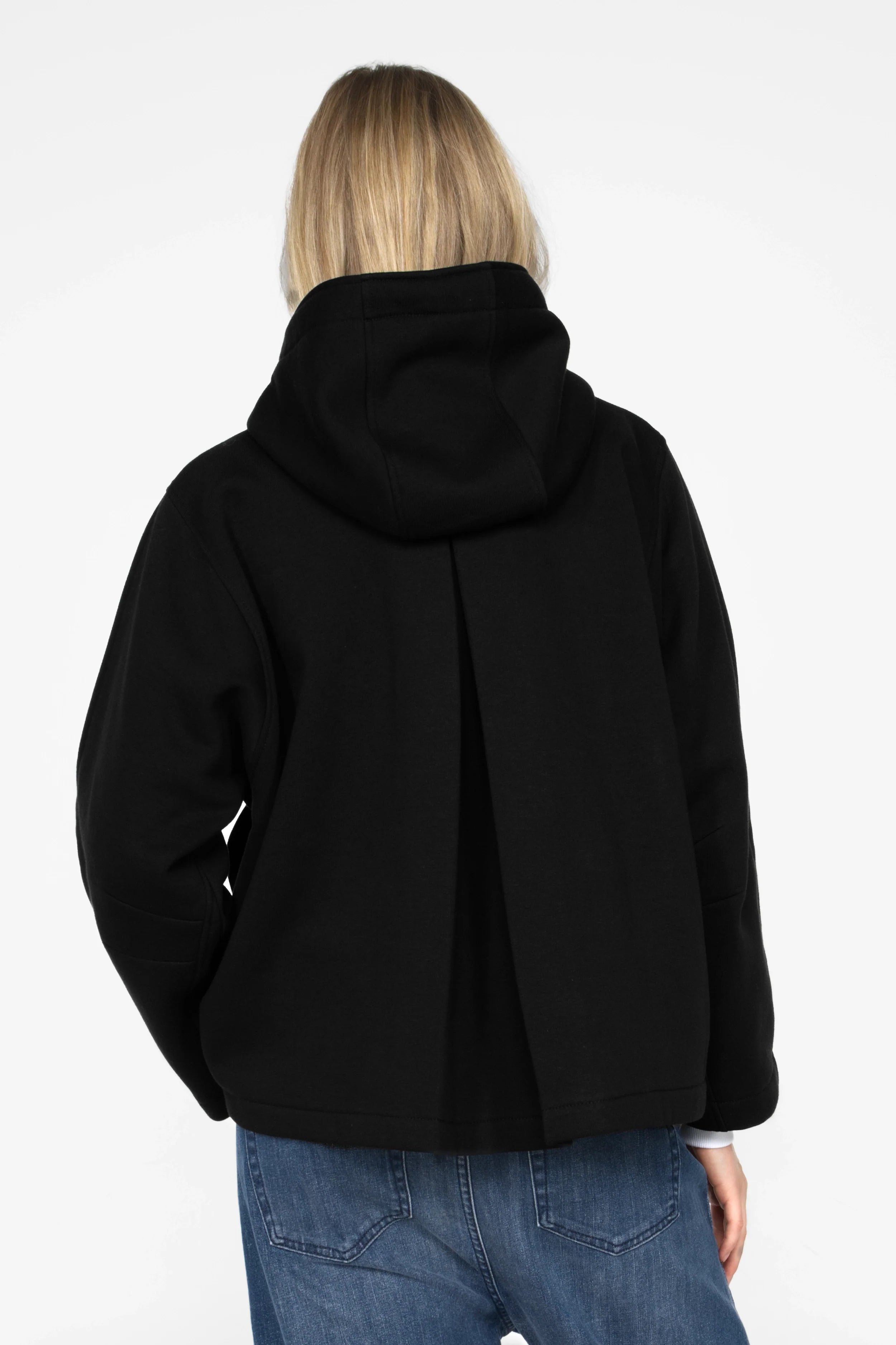 Frau trägt schwarze ELFA Sweatjacke mit Kapuze und Kellerfalte hinten, Rückansicht
