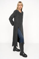Woman wearing black EMEDY Longbluse Tunika with round neckline, side slit, and relaxed fit over jeans and black boots