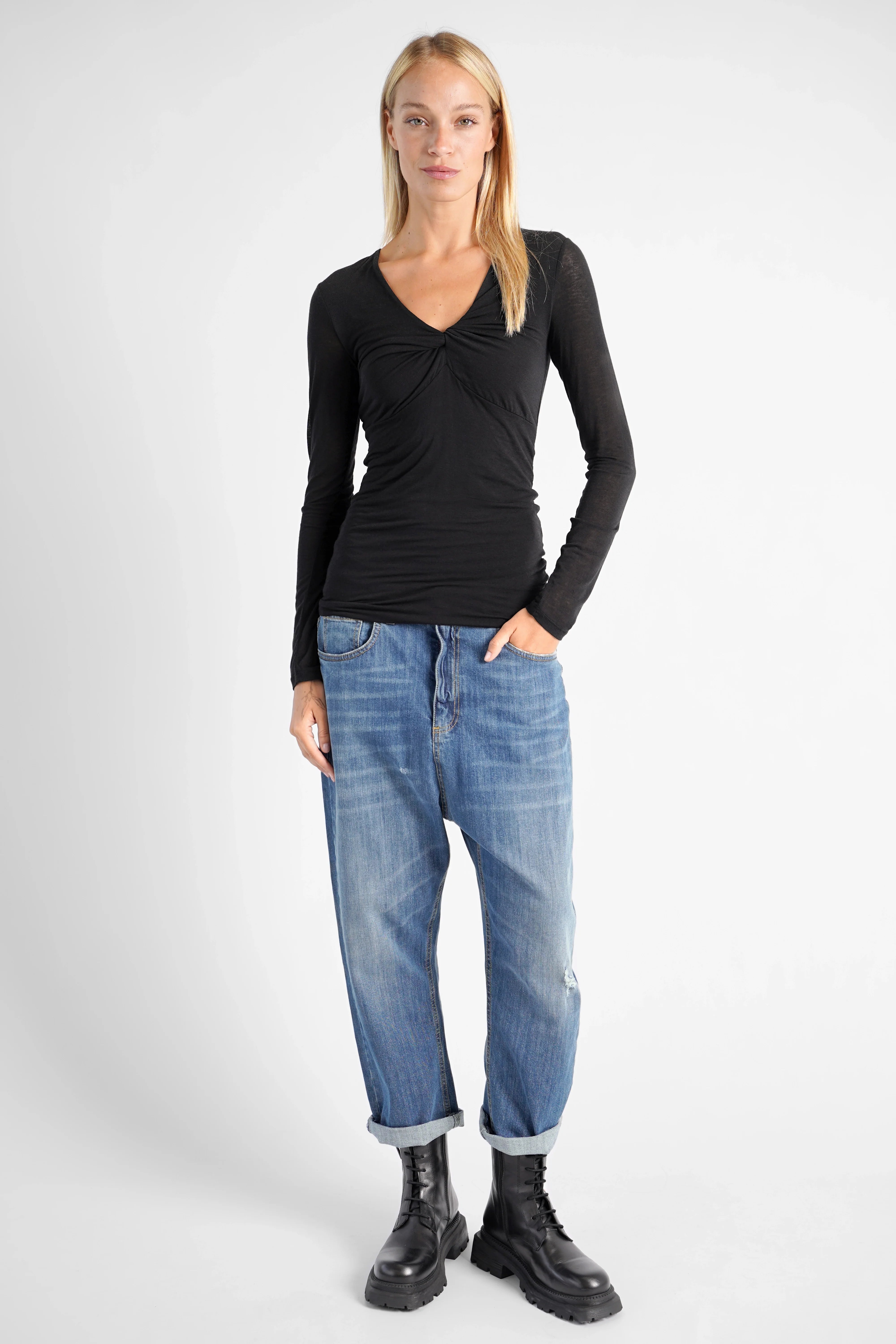 FLURRI Longsleeve black slim fit cashmere blend top with V-neck twist detail worn by model with jeans and boots