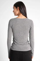 Back view of a woman wearing a grey FLURRI Longsleeve slim-fit shirt made from a soft cashmere blend with long sleeves and a smooth texture