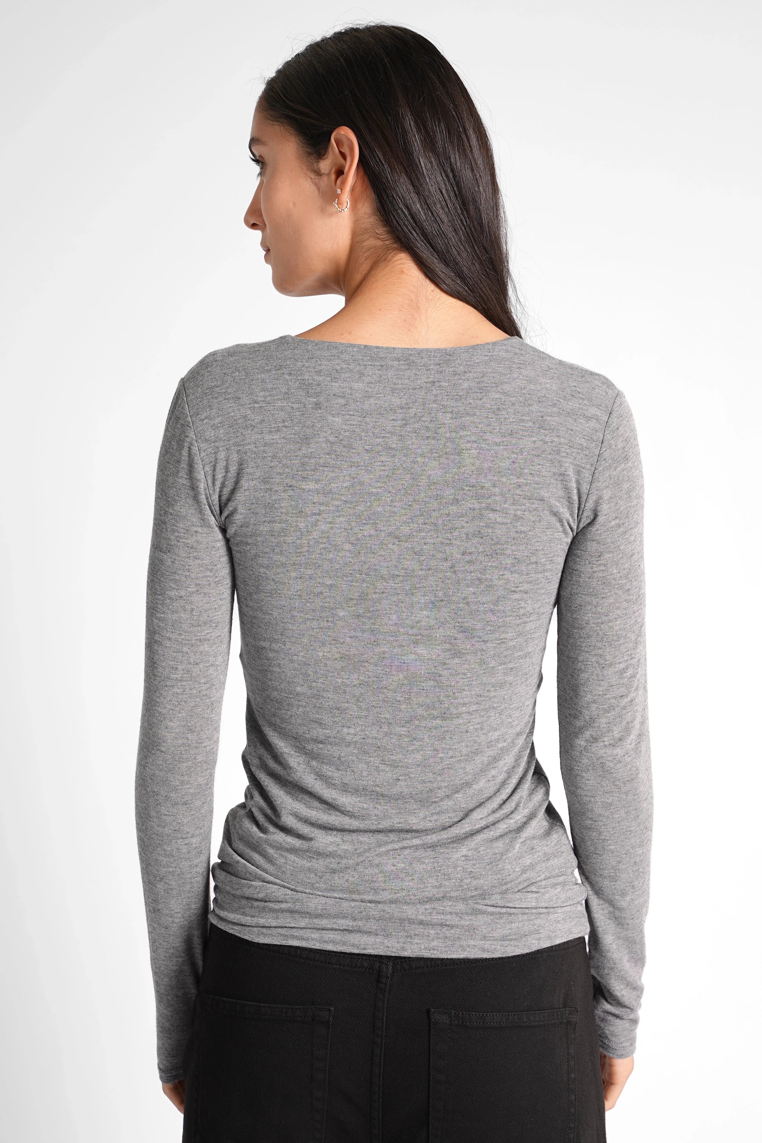 Back view of a woman wearing a grey FLURRI Longsleeve slim-fit shirt made from a soft cashmere blend with long sleeves and a smooth texture