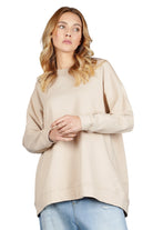 Damen trägt beigen GRACEY.K Sweater mit Oversize-Schnitt und Rundhalsausschnitt