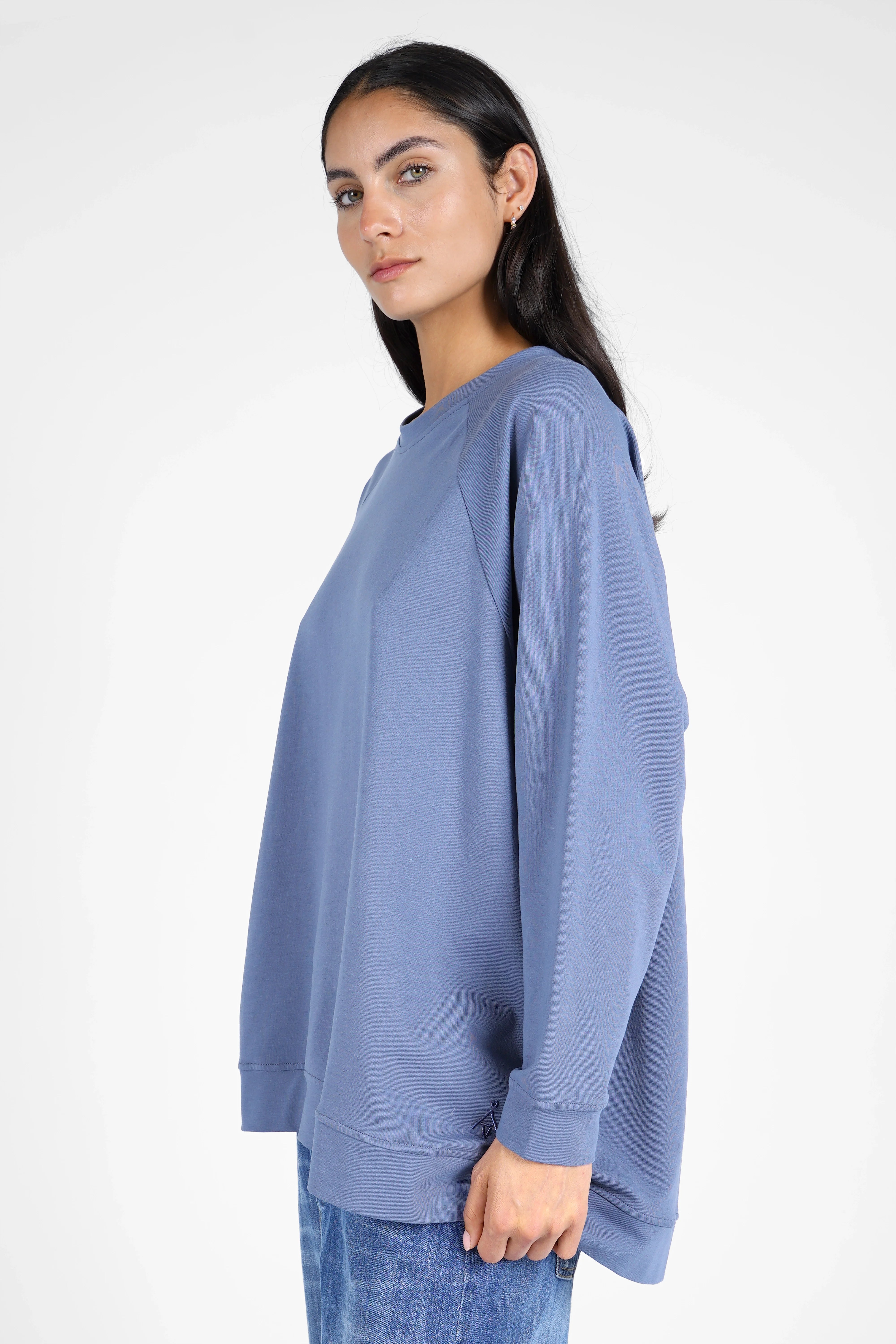 Damen trägt lässigen GRACEY.K Sweater in Oversize mit A-Linie und tonaler Logo-Stickerei