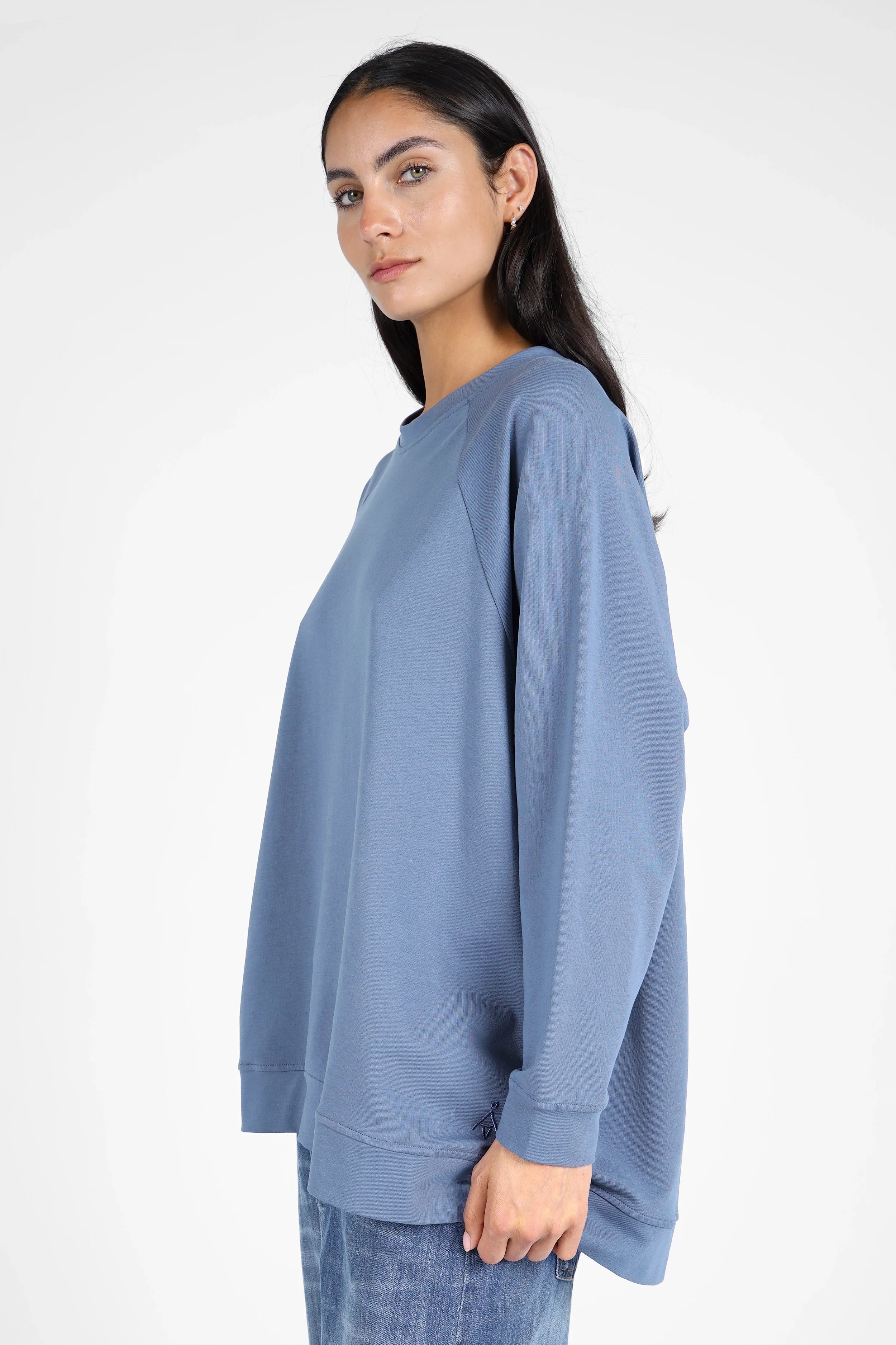 Damen trägt lässigen GRACEY.K Sweater in Blau mit A-Linie, Raglanärmeln und tonaler Logo-Stickerei