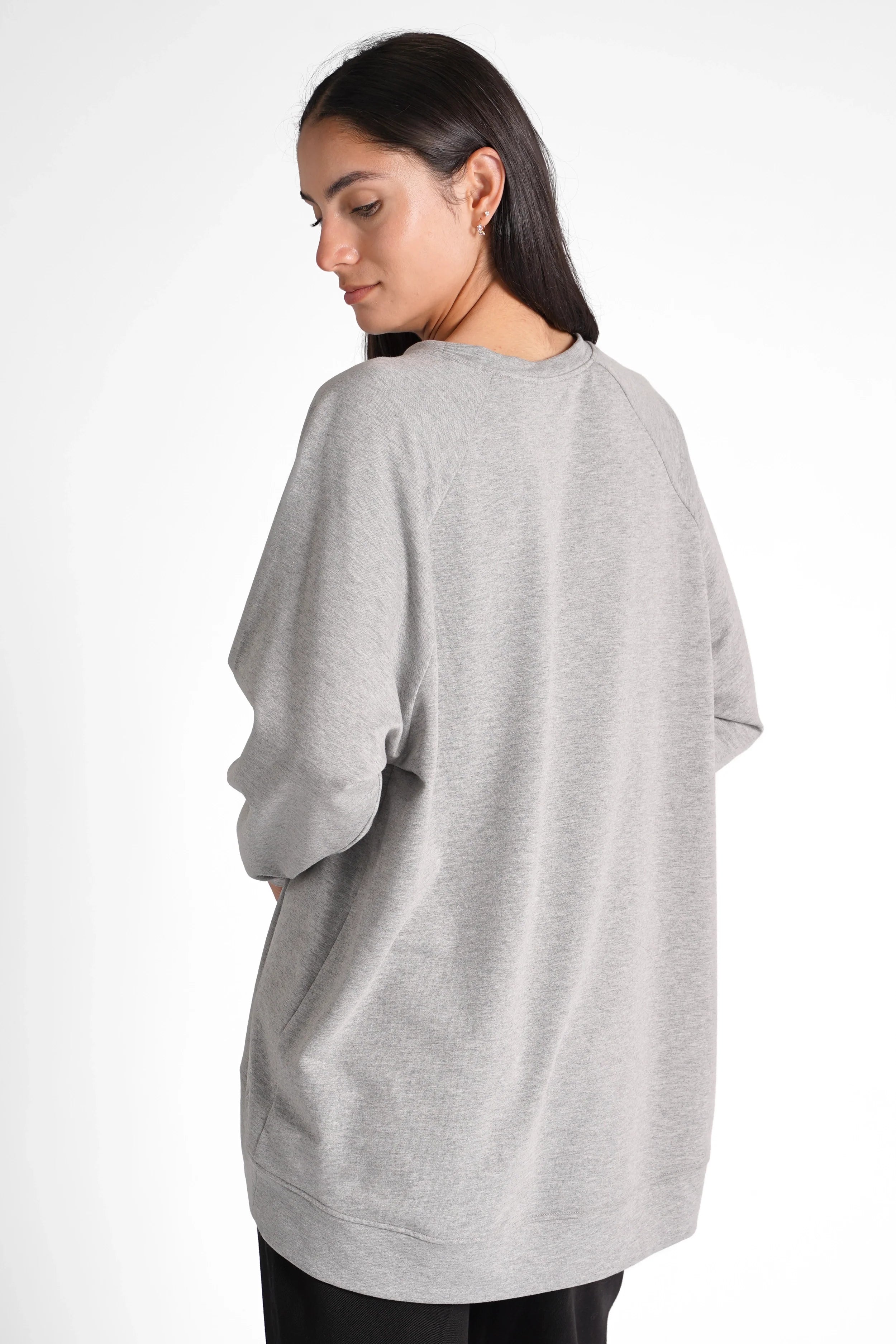 Woman wearing oversized grey GRACEY.K Sweater with rounded hem and tonal logo embroidery, back view
