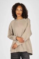 Woman wearing beige oversized GRACEY.K Sweater with round neckline and tonal logo embroidery
