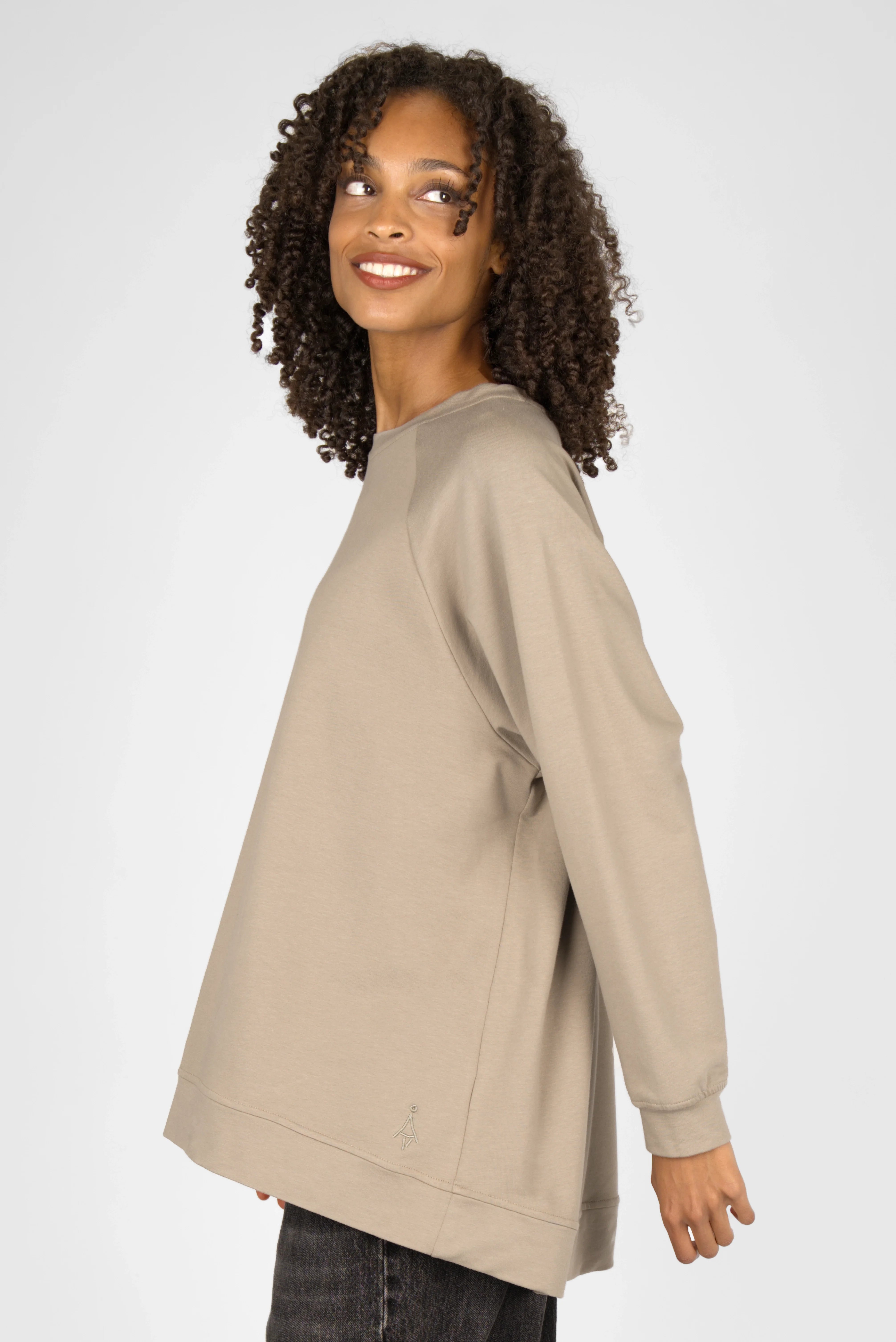 Woman wearing oversized beige GRACEY.K Sweater with round neckline and tonal logo embroidery