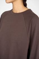 Close-up of a brown GRACEY.K Sweater with round neckline and tonal logo embroidery in oversized fit