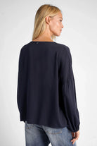 Dunkelblaue GRETA.K V-Neck Bluse aus leichter Viskose mit Ballonärmeln, locker fallend, Rücklänge ca. 60 cm, getragen von Modell in Größe S