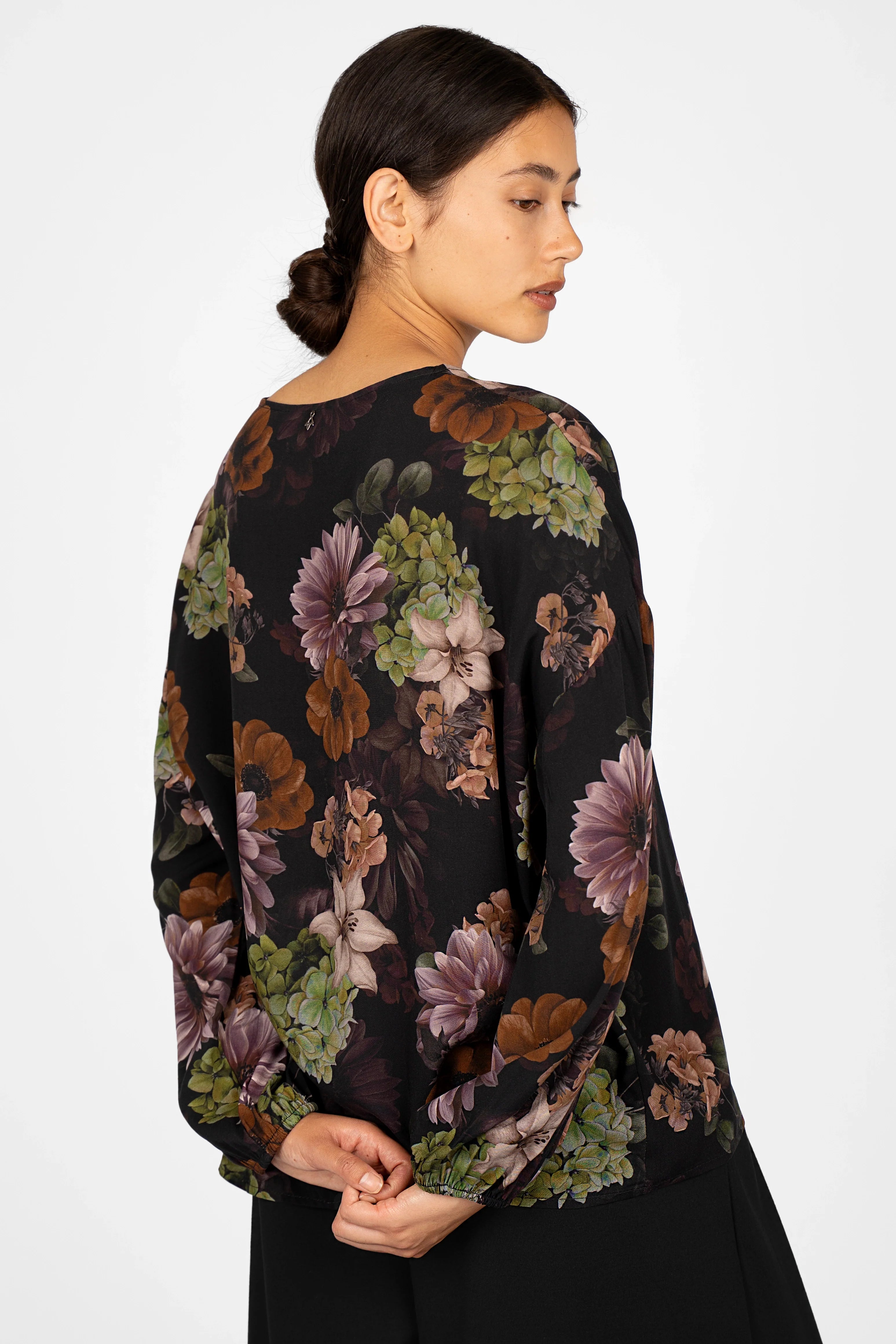 Woman wearing GRETA.K Bluse with allover floral print, round neck, and lightweight balloon sleeves, back view