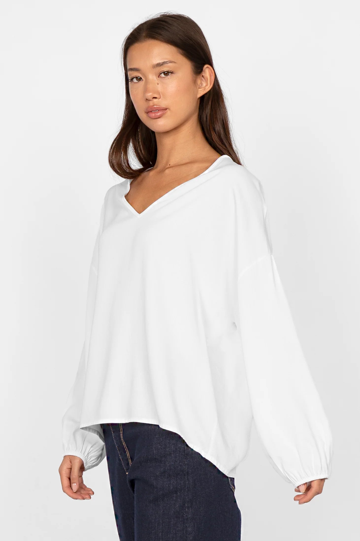 Damen trägt weiße GRETA.K V-Neck Bluse mit lockerem Schnitt und elastischen Ärmeln