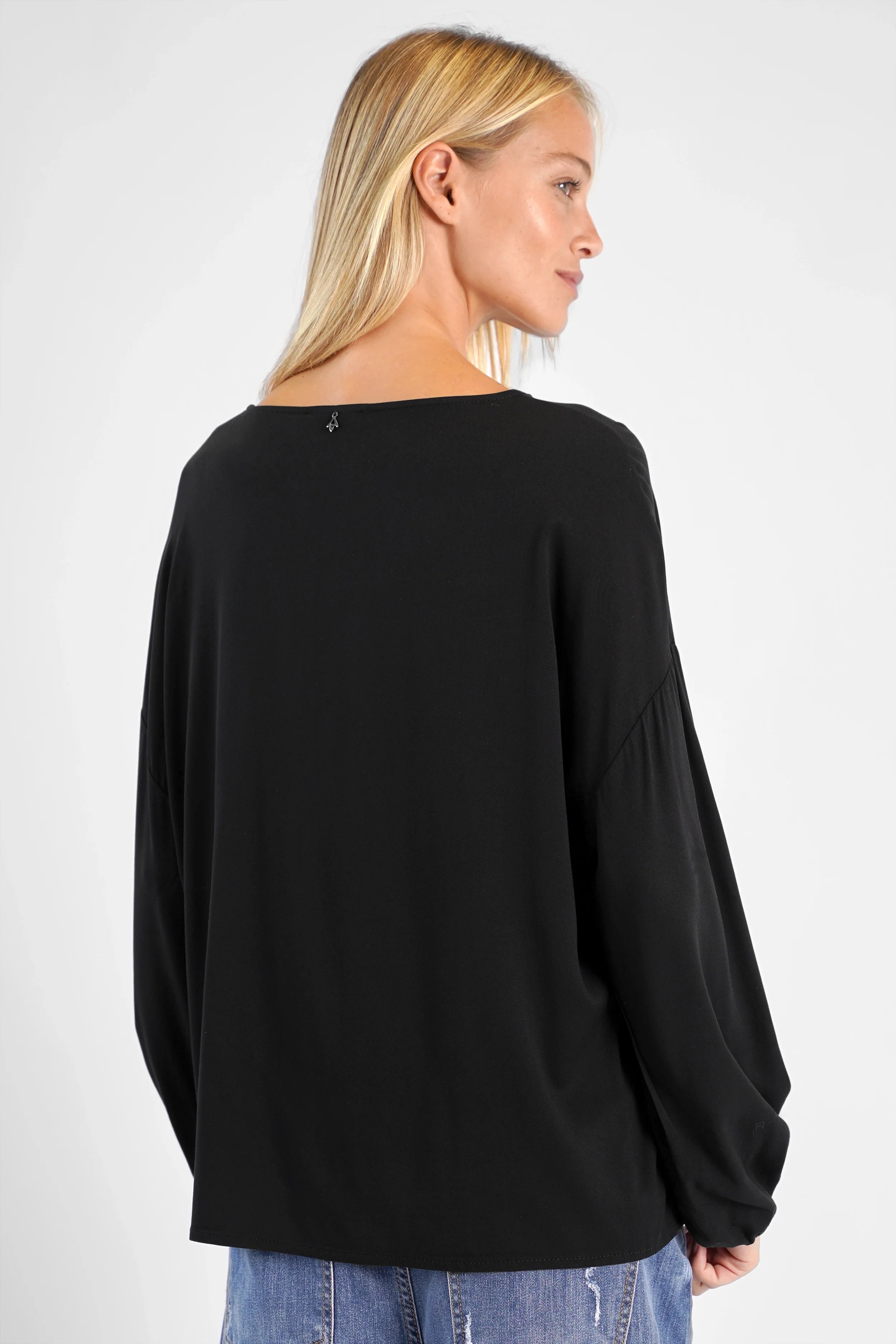 Frau trägt schwarze GRETA.K Bluse aus leichter Viskose mit Rundhals und Ballonärmeln, Rücklänge ca. 60 cm