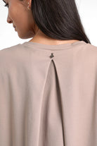 Close-up of the back of a taupe HAGLA Shirt featuring a subtle pleat and round neckline made from soft, wrinkle-free viscose blend fabric.