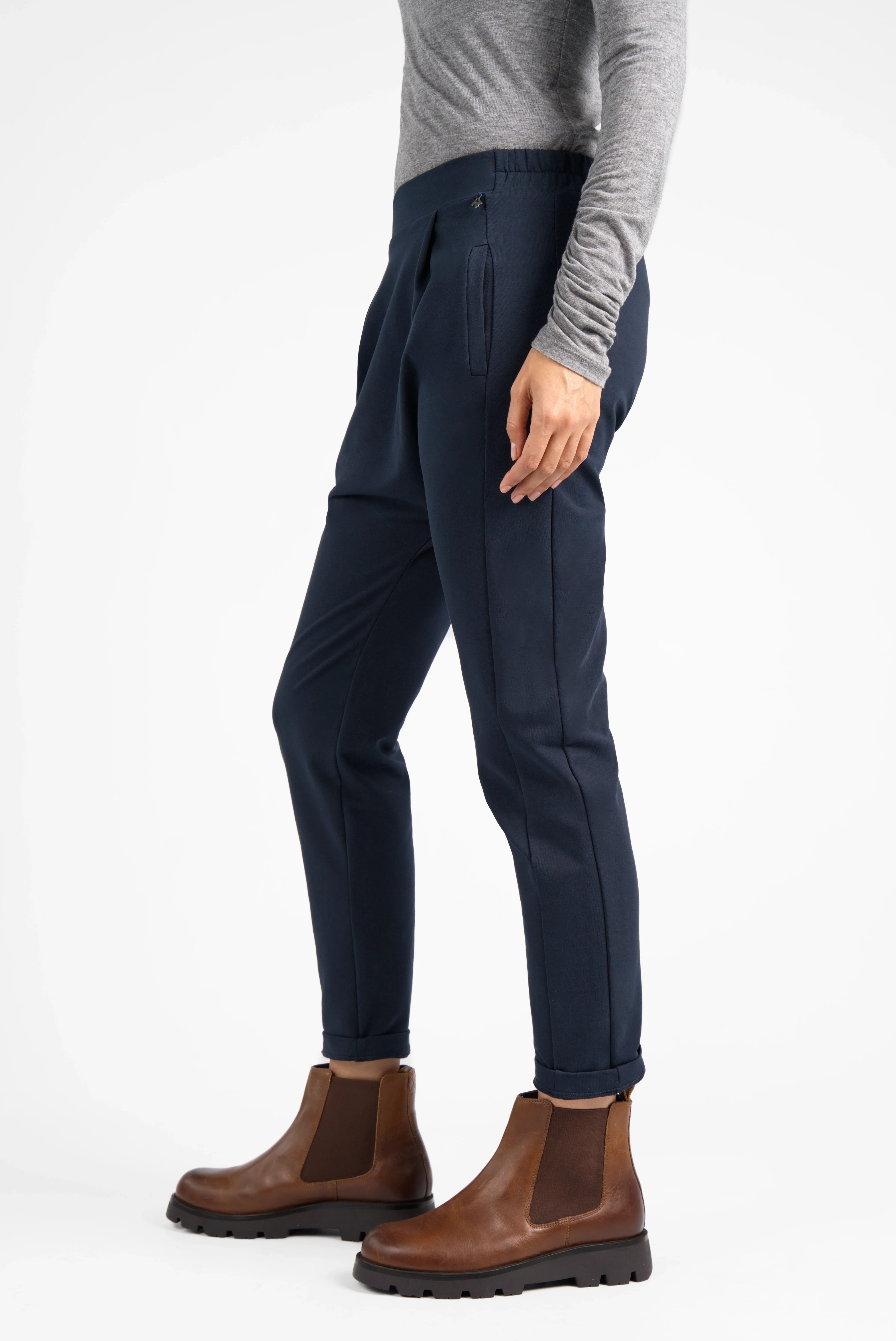 HANNA.K Tapered Sweathose dunkelblau mit elastischem Bund und schmal zulaufendem Bein, kombiniert mit grauem Oberteil und braunen Boots