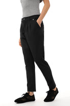 Black tapered pants with relaxed fit and tapered leg, featuring a soft, wrinkle-resistant fabric and zipper closure.