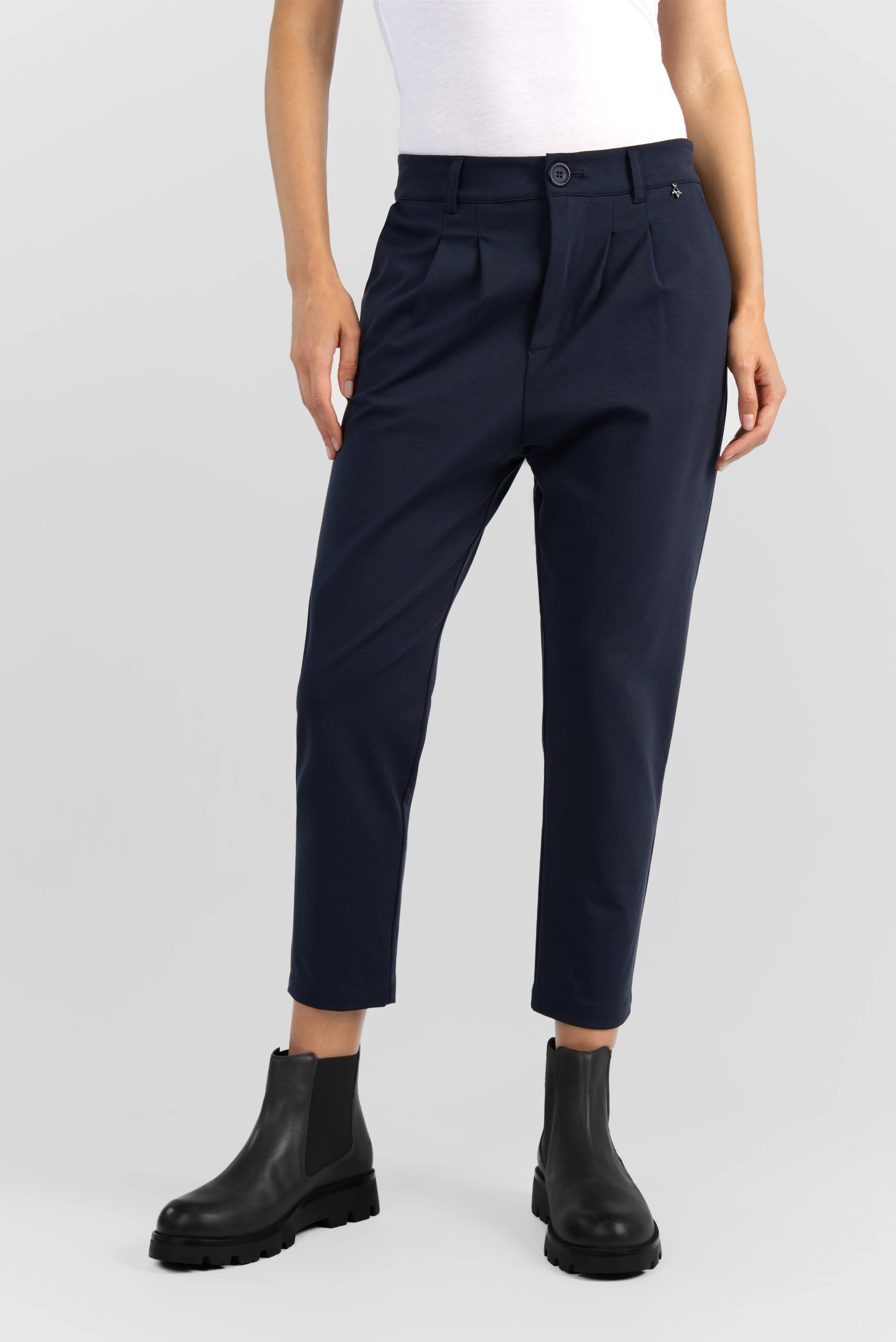Dunkelblaue HEELENA OG Tapered Pants Cropped mit schmal zulaufendem Bein und legerem Sitz, kombiniert mit schwarzen Stiefeln.